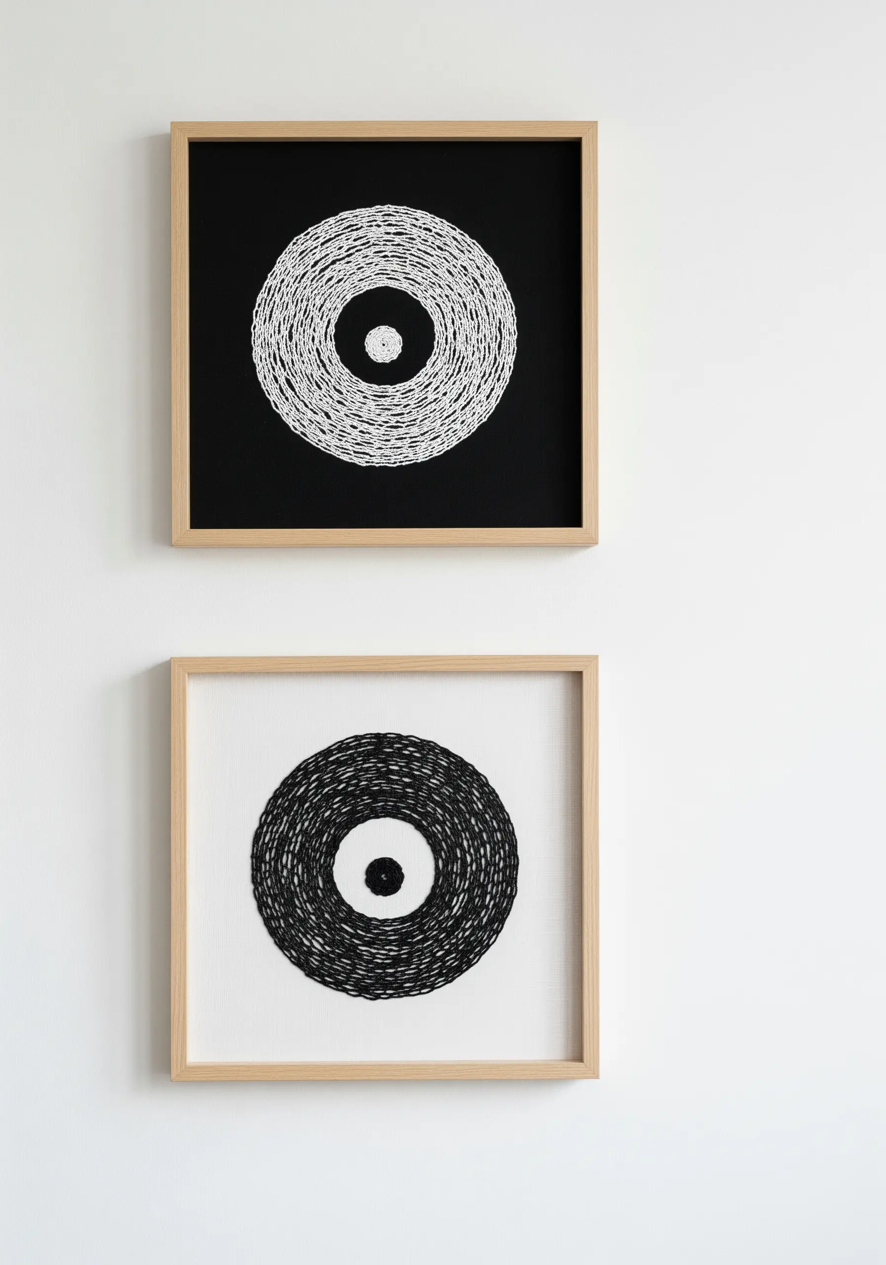 Two framed pieces showing circular shapes filled with dense, scribbled black and white stitches.
