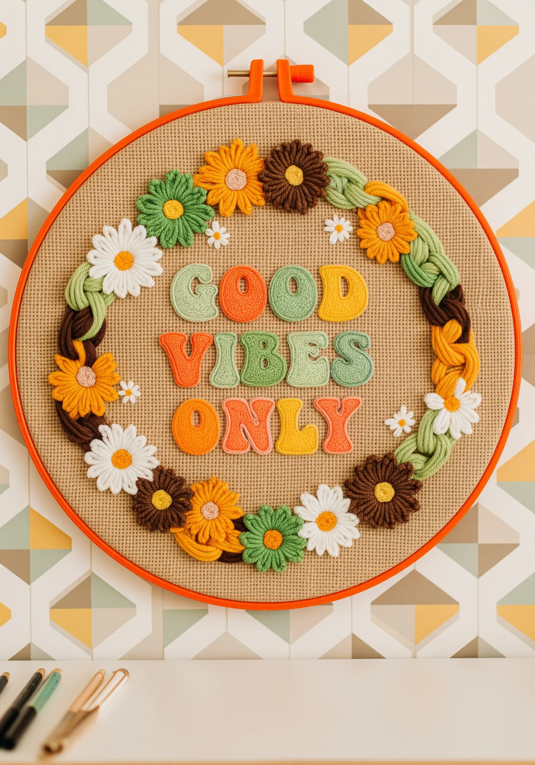 Retro-style embroidery with chunky yarn lettering and a thick, braided floral border.
