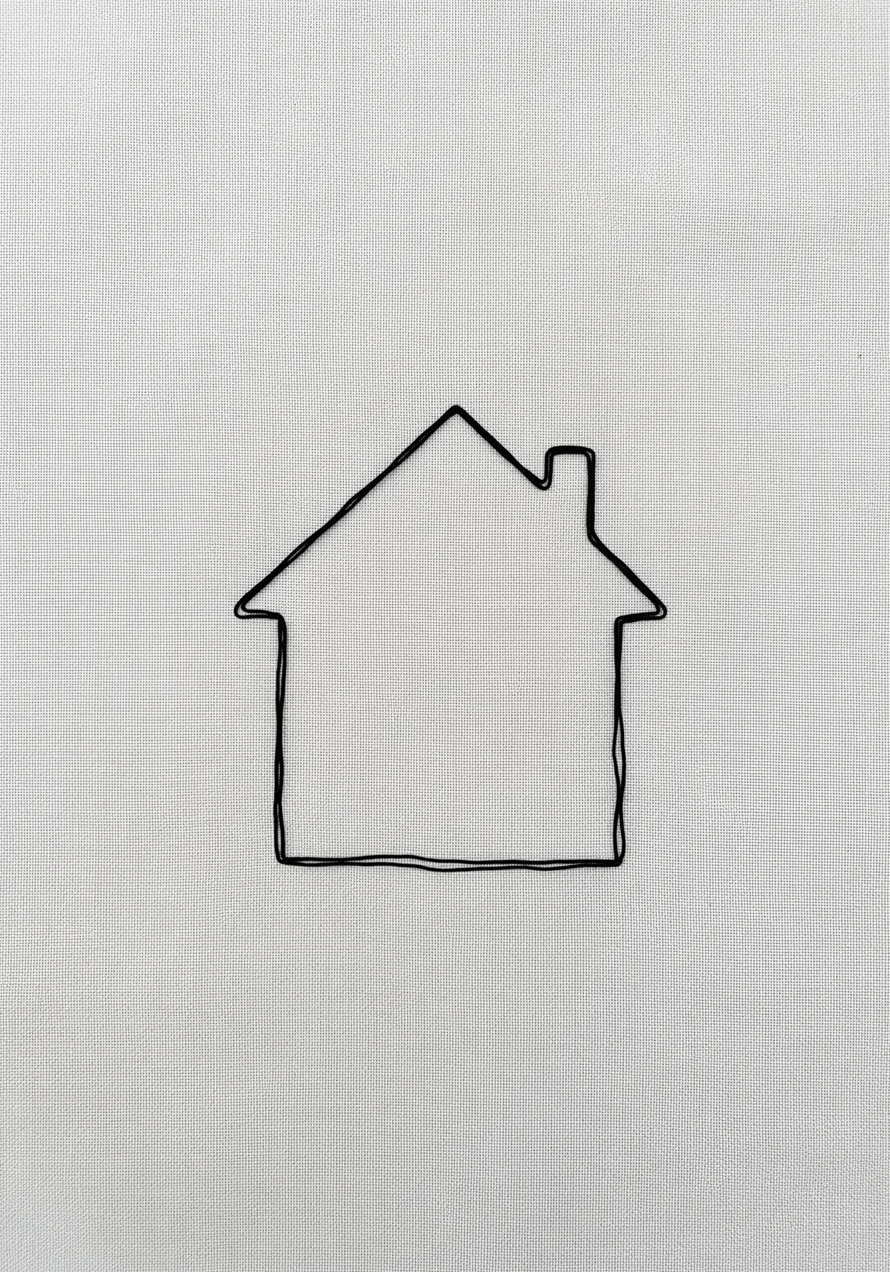 A minimal outline of a house stitched with a single black line on white fabric.