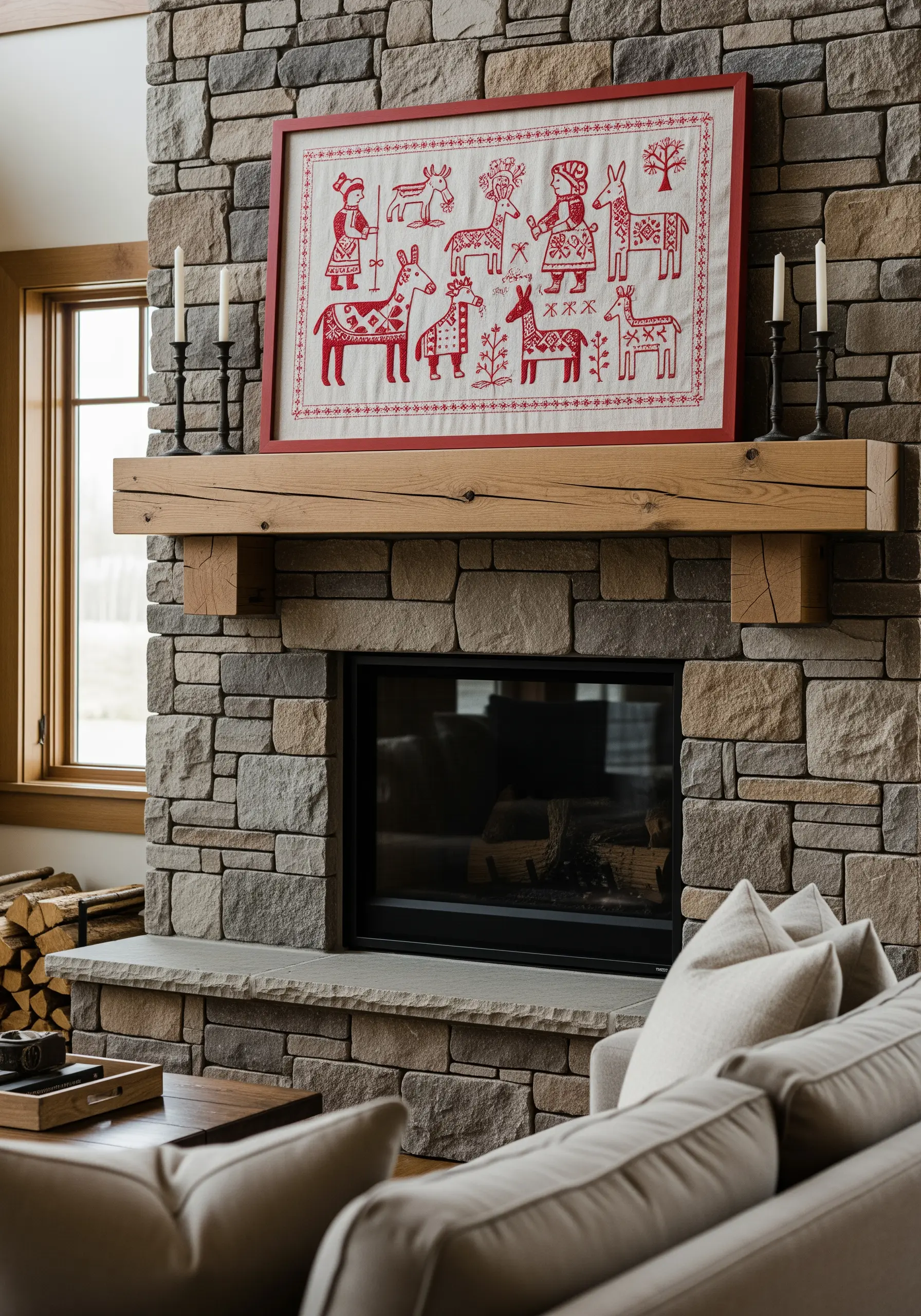 A large framed folk art embroidery sampler in red thread on off-white linen, depicting stylized animals and people.