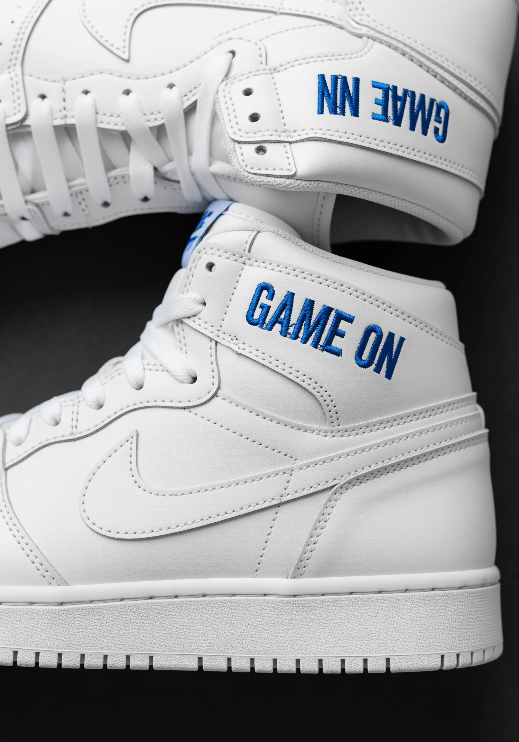 “GAME ON” embroidered in bold blue letters on the side of a white high-top sneaker.