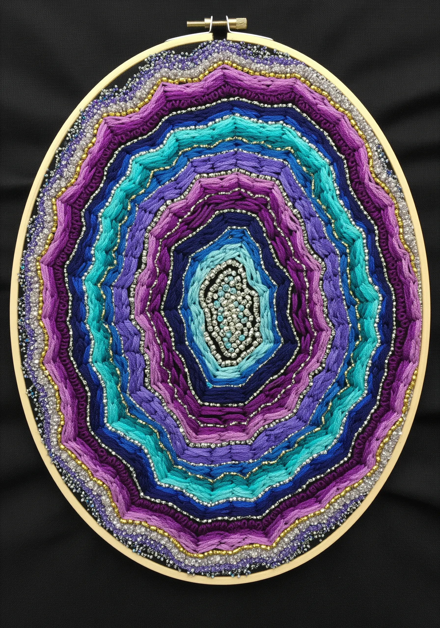 Embroidery hoop art of a geode slice with concentric rings of purple and blue yarn and beads.