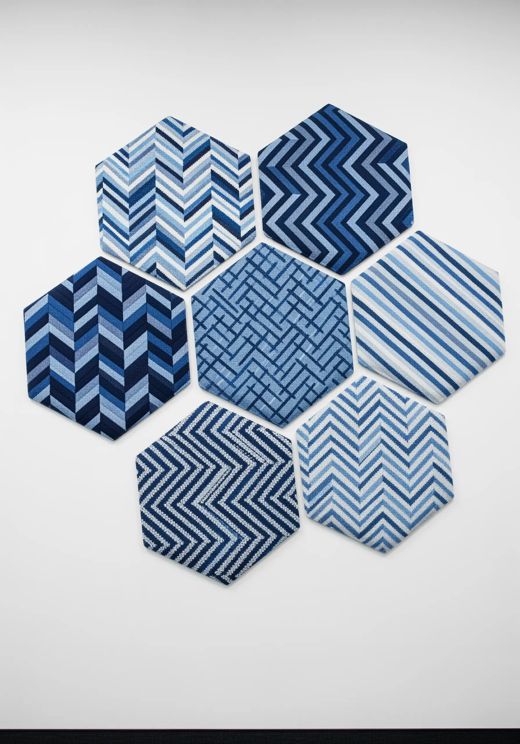 A collection of seven hexagonal canvases filled with various blue geometric bargello patterns.