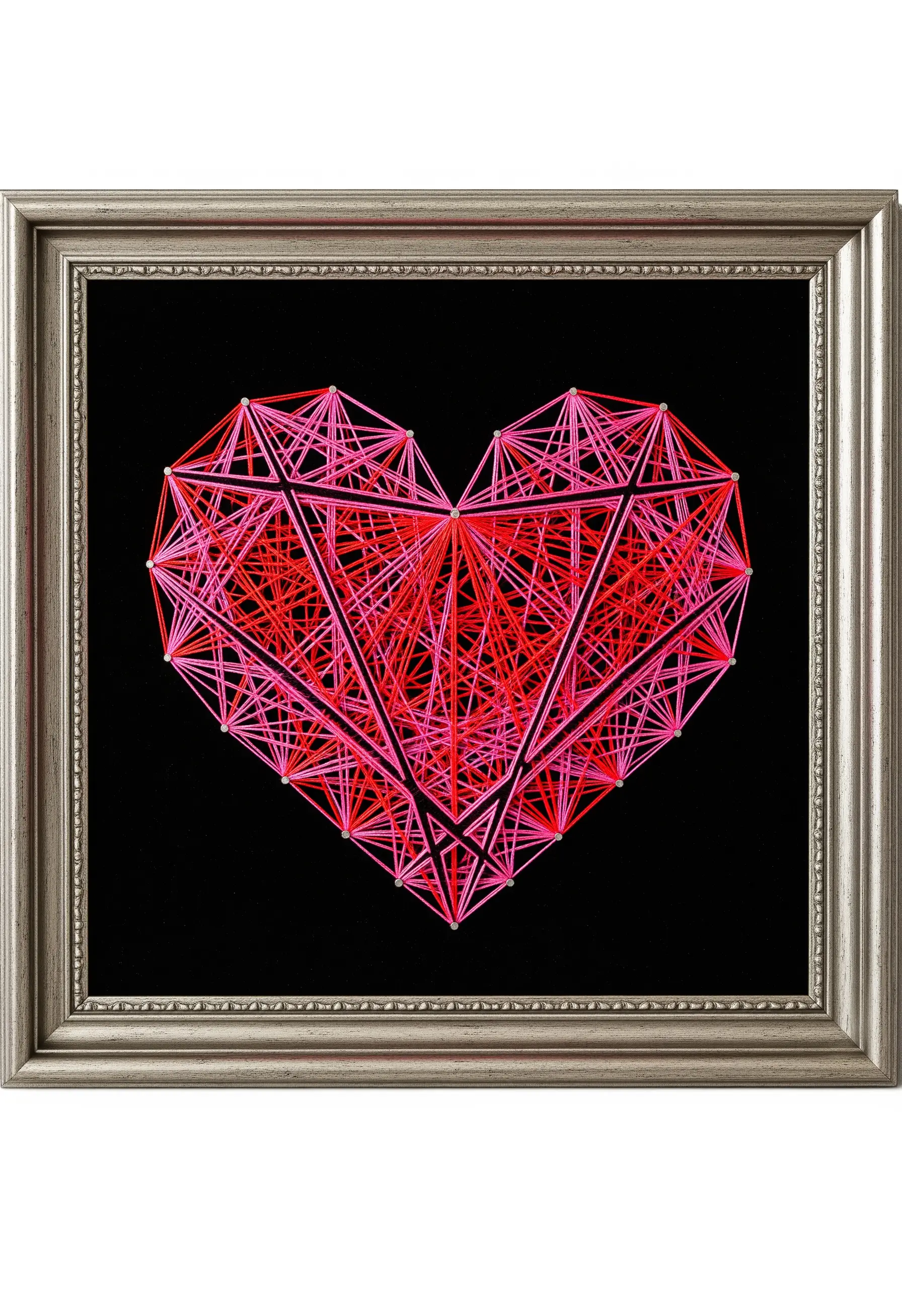 A complex geometric heart embroidered with layers of red and pink thread on black fabric.