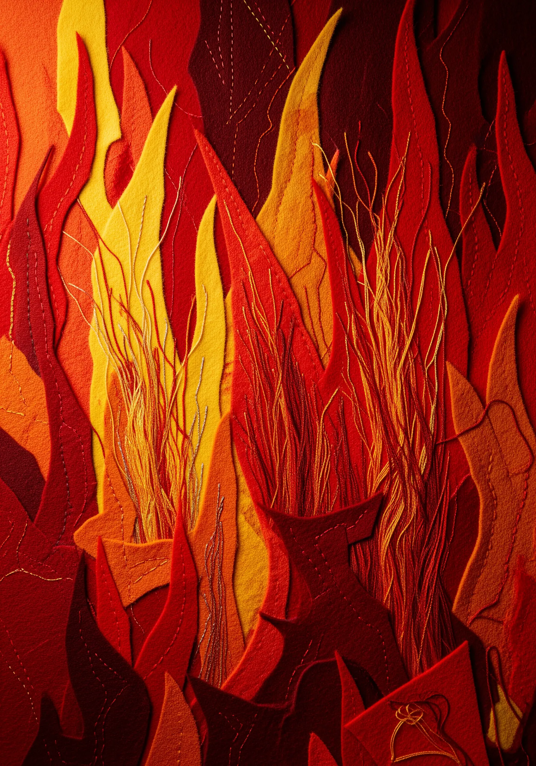A vibrant collage of red, orange, and yellow felt flames with dense thread-painting.