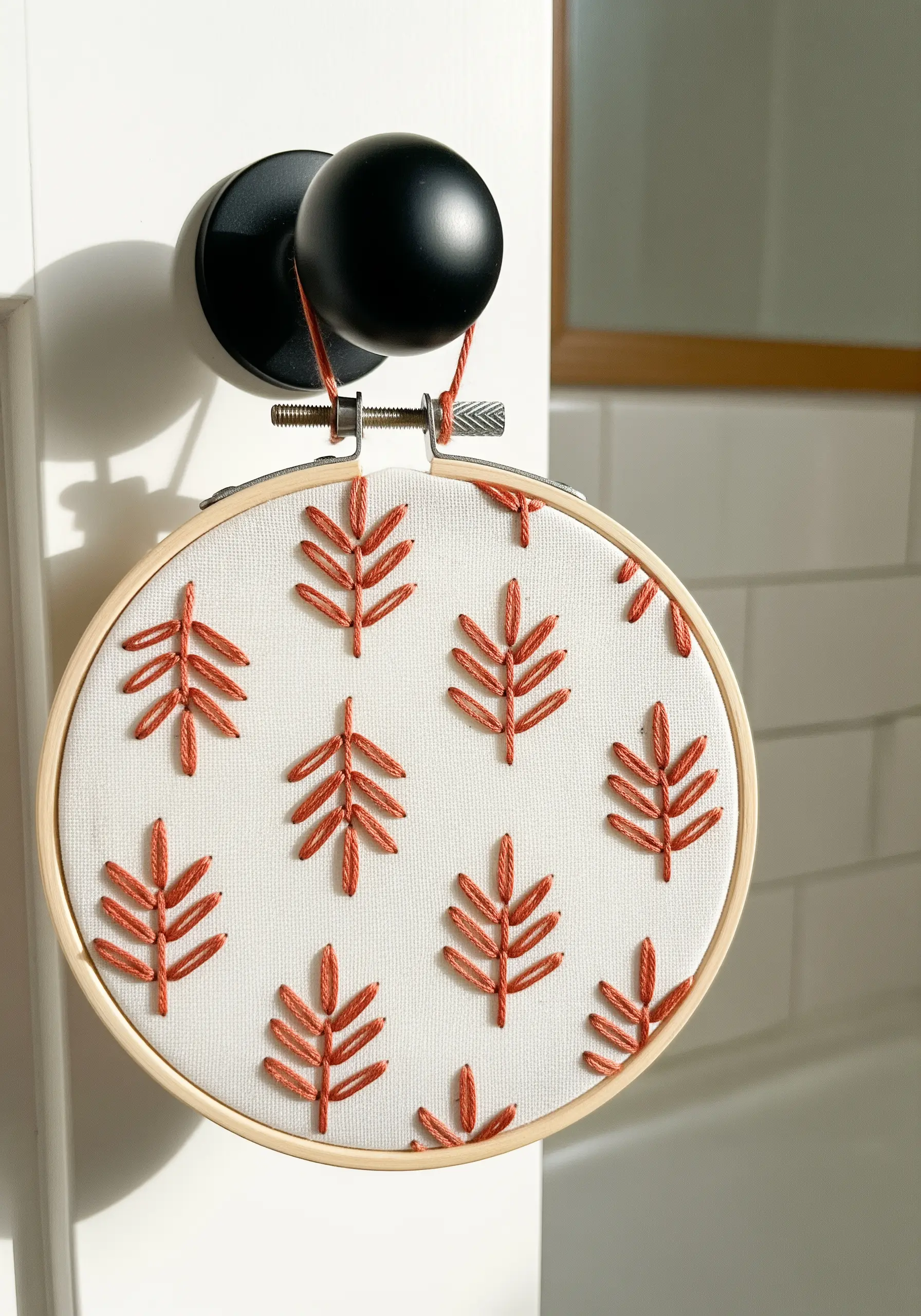 A repeating pattern of small leaves embroidered in a terracotta variegated thread.