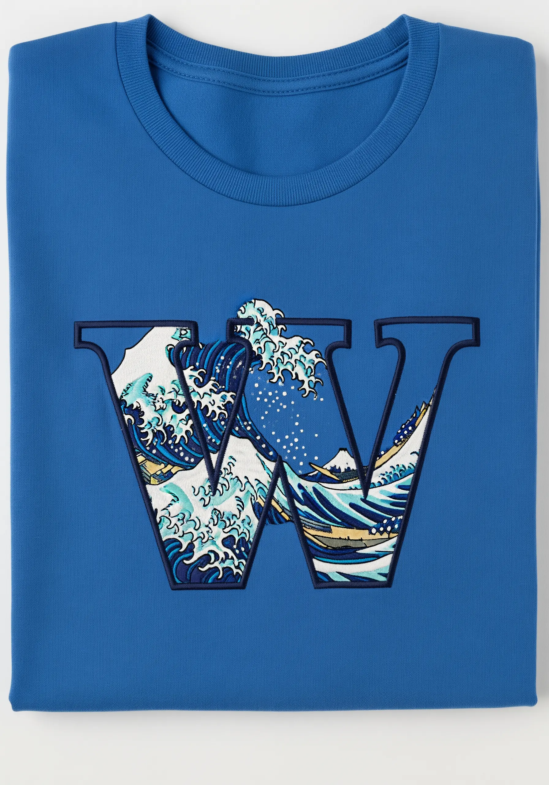Letter 'W' with a thick embroidered outline, filled with a fabric appliqué of 'The Great Wave'.