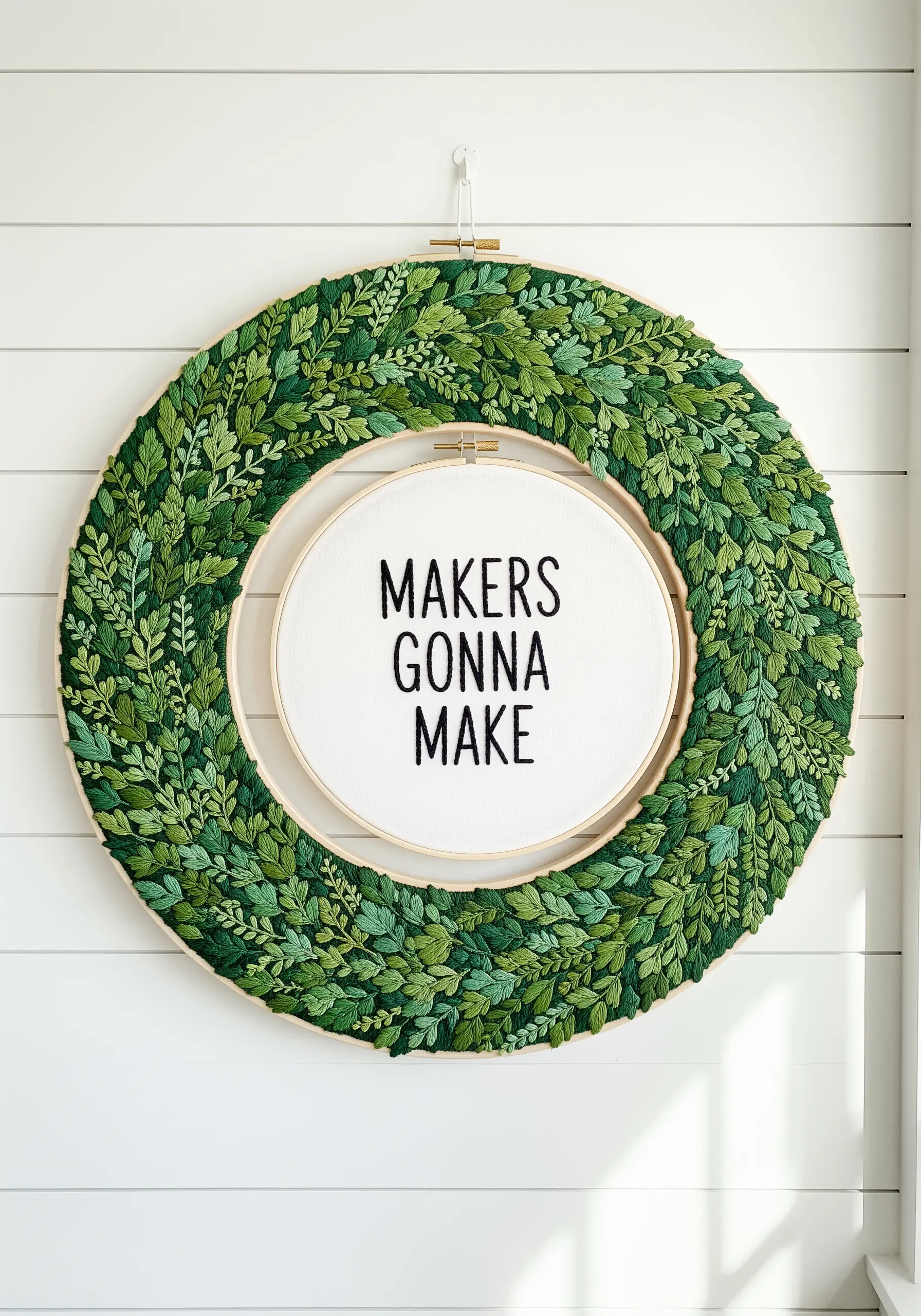 Double hoop wreath with dense green foliage and central text
