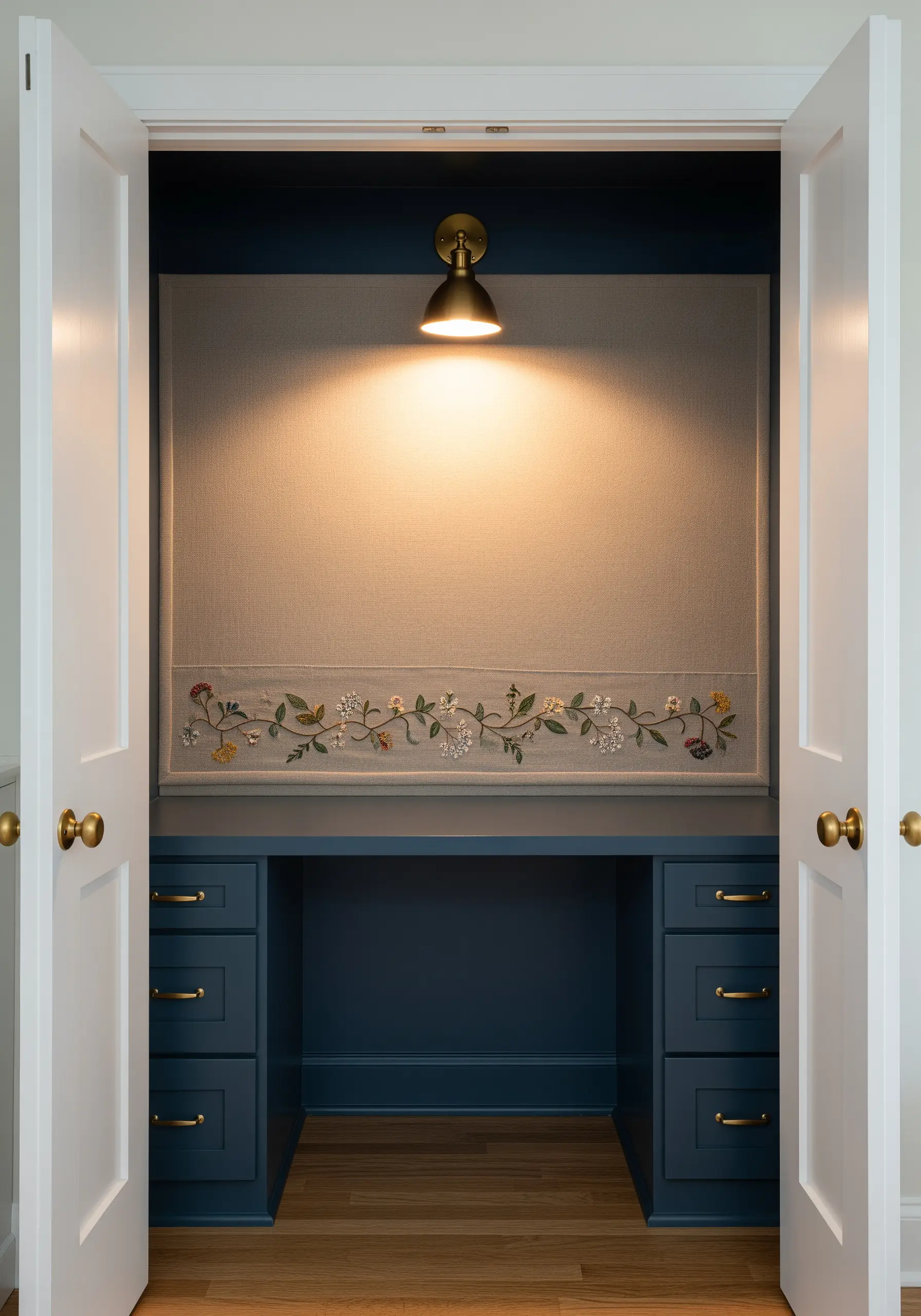 A long, horizontal embroidery of delicate wildflowers on a fabric panel in a closet office.