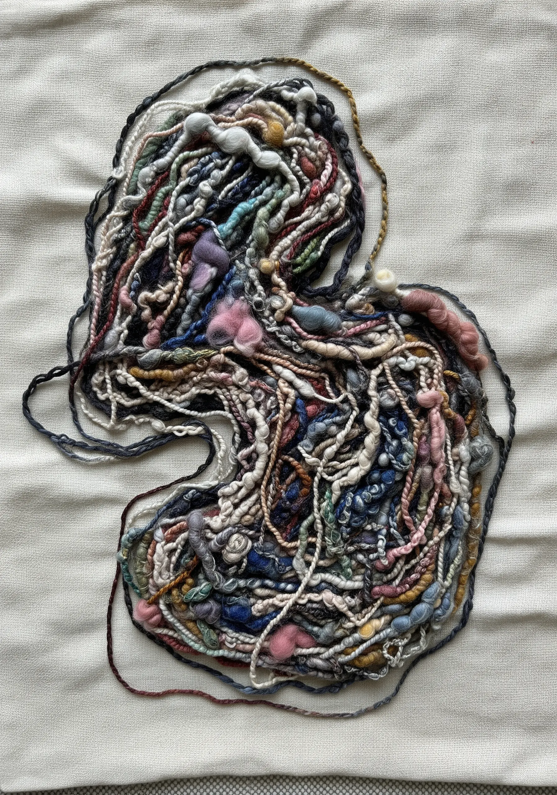 Abstract textural embroidery created with a collage of multi-colored, hand-spun art yarn.