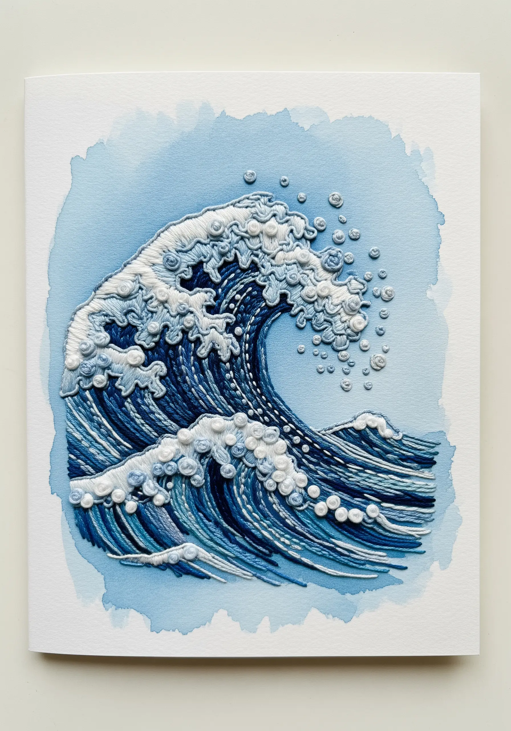An embroidered ocean wave on a watercolor background, with French knots for sea foam.