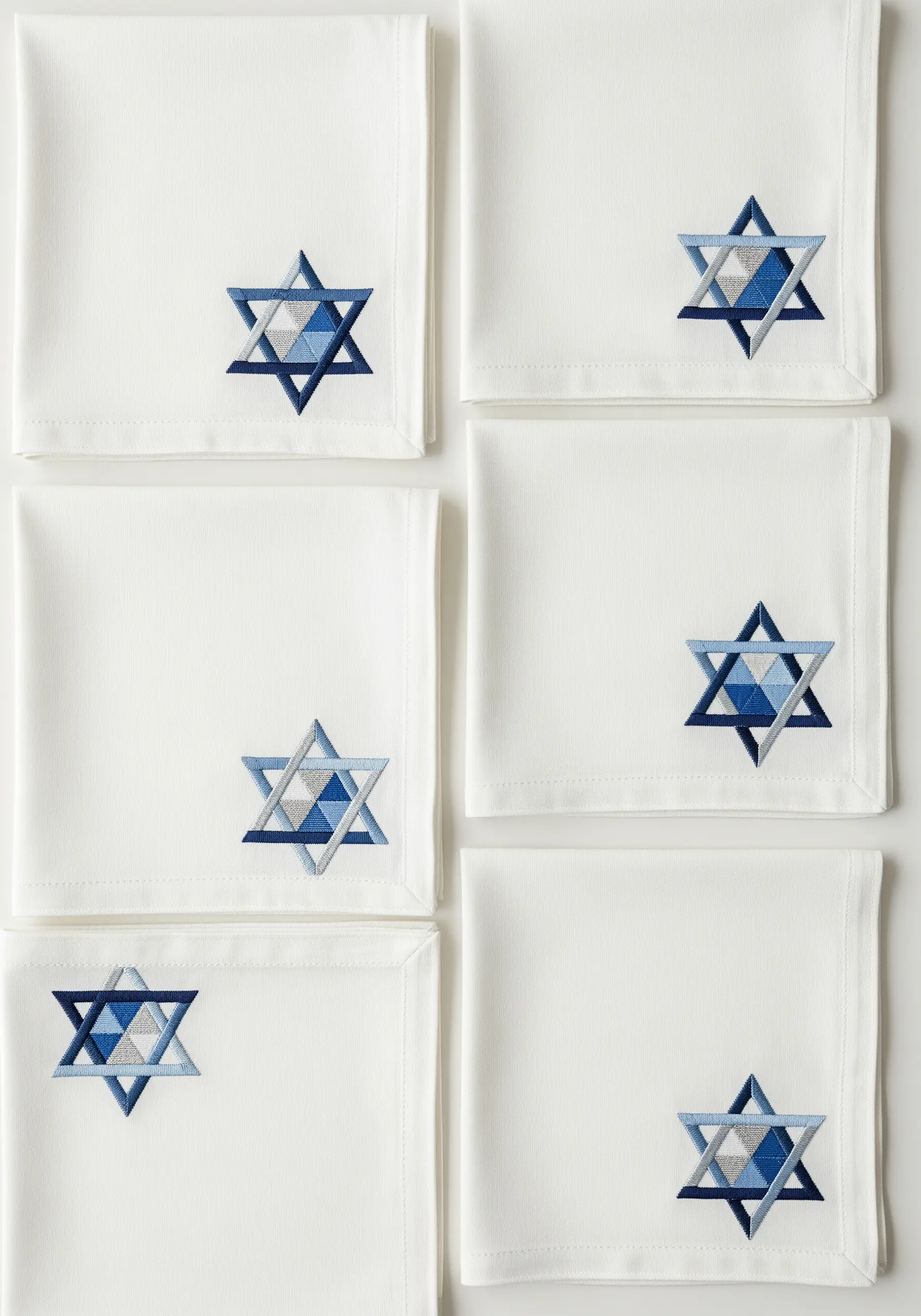 Geometric Star of David embroidered on napkins with blue, gray, and silver thread.