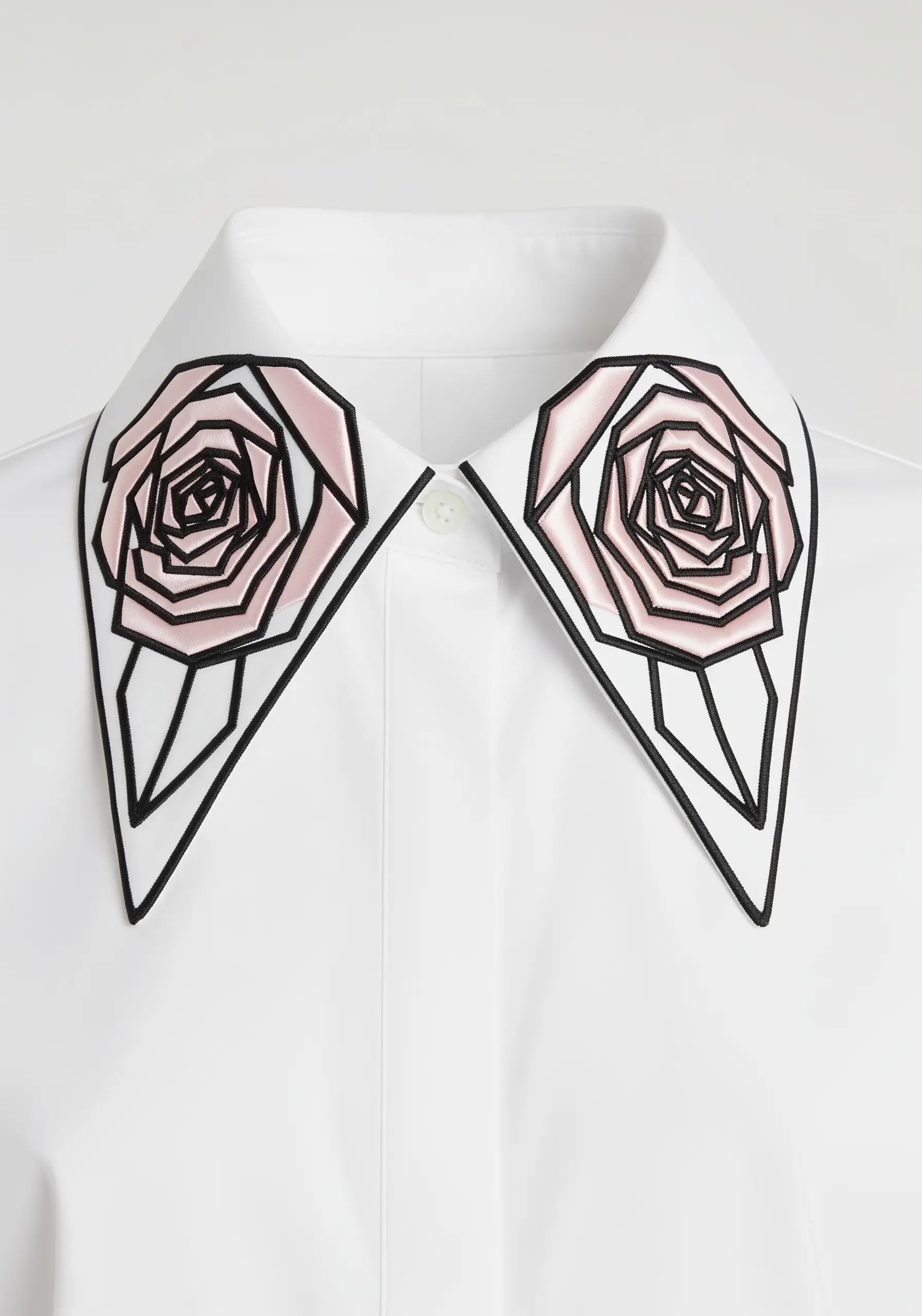 Modern, geometric roses with pink fabric appliqué and bold black outlines on a white collar.