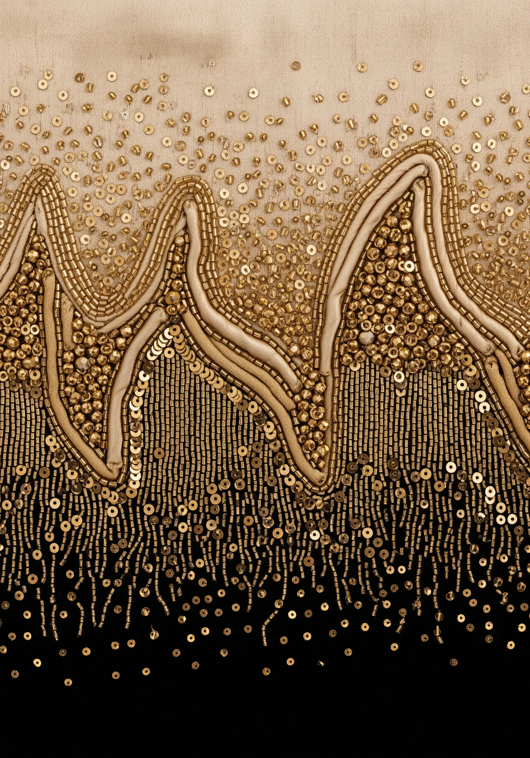 A luxurious gradient of gold beads and sequins, transitioning from dense to sparse on fabric.