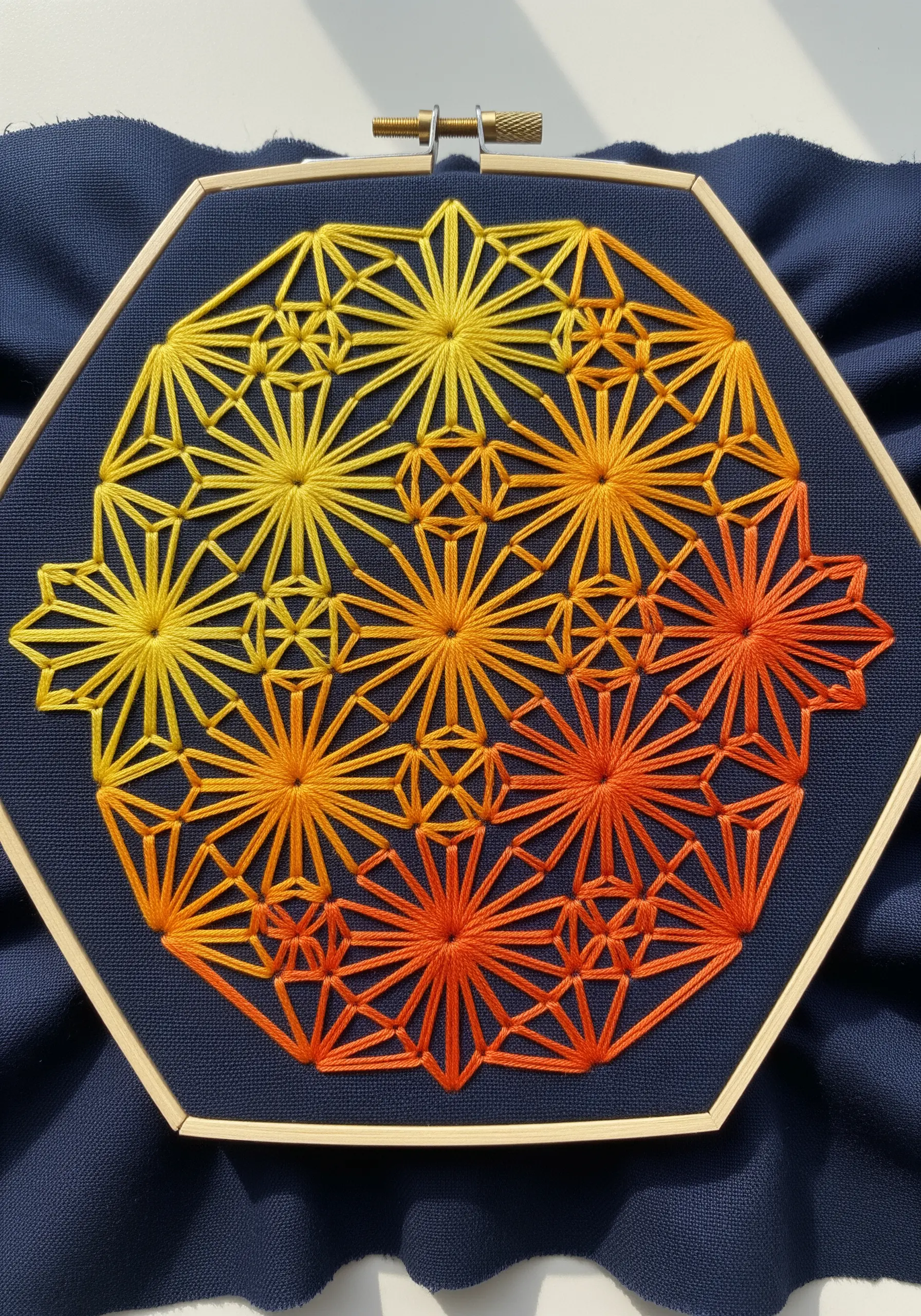 A geometric star pattern in a hexagon hoop with a smooth yellow-to-orange gradient.