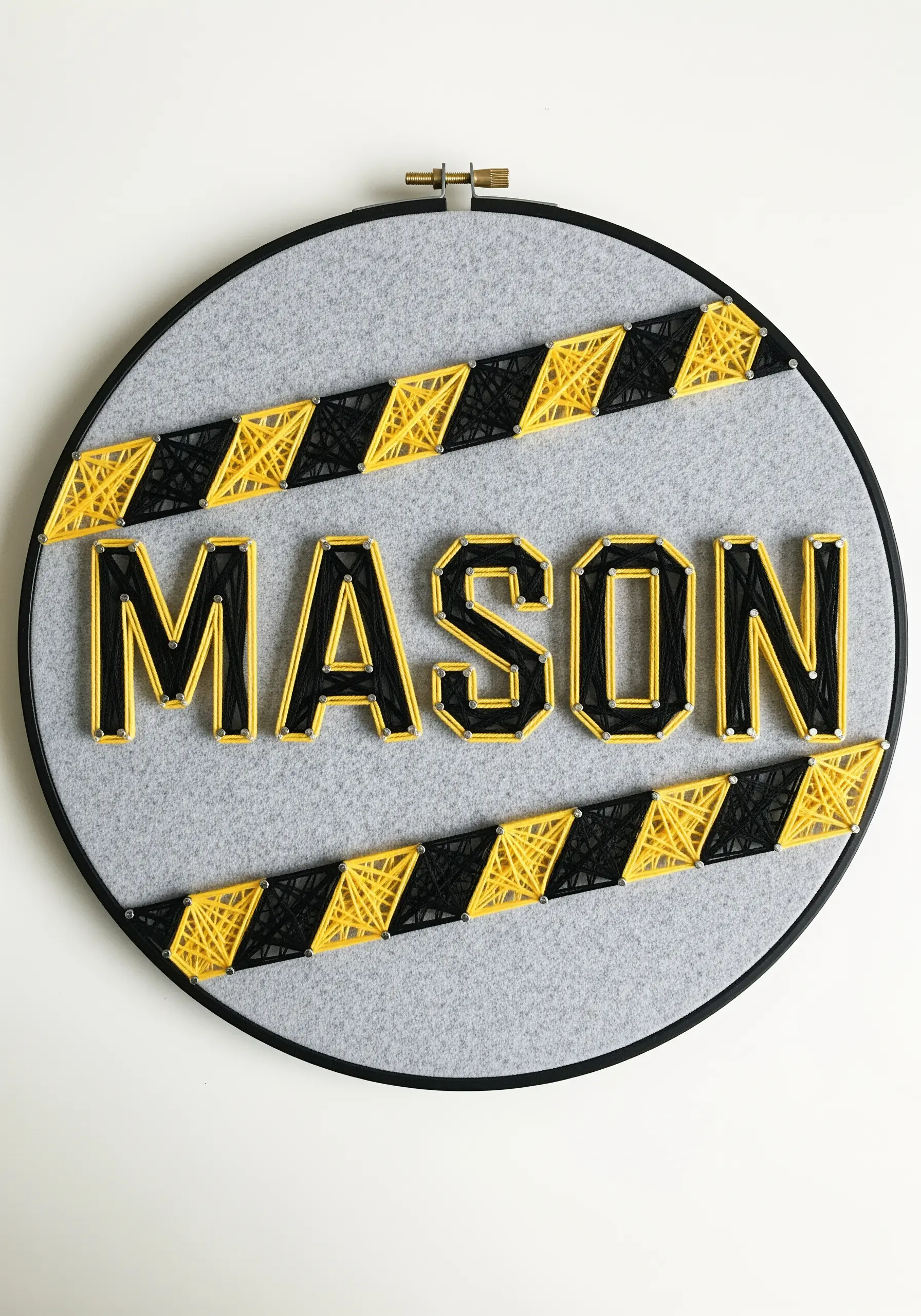A name embroidered in black and yellow with industrial-style caution stripes on gray felt.