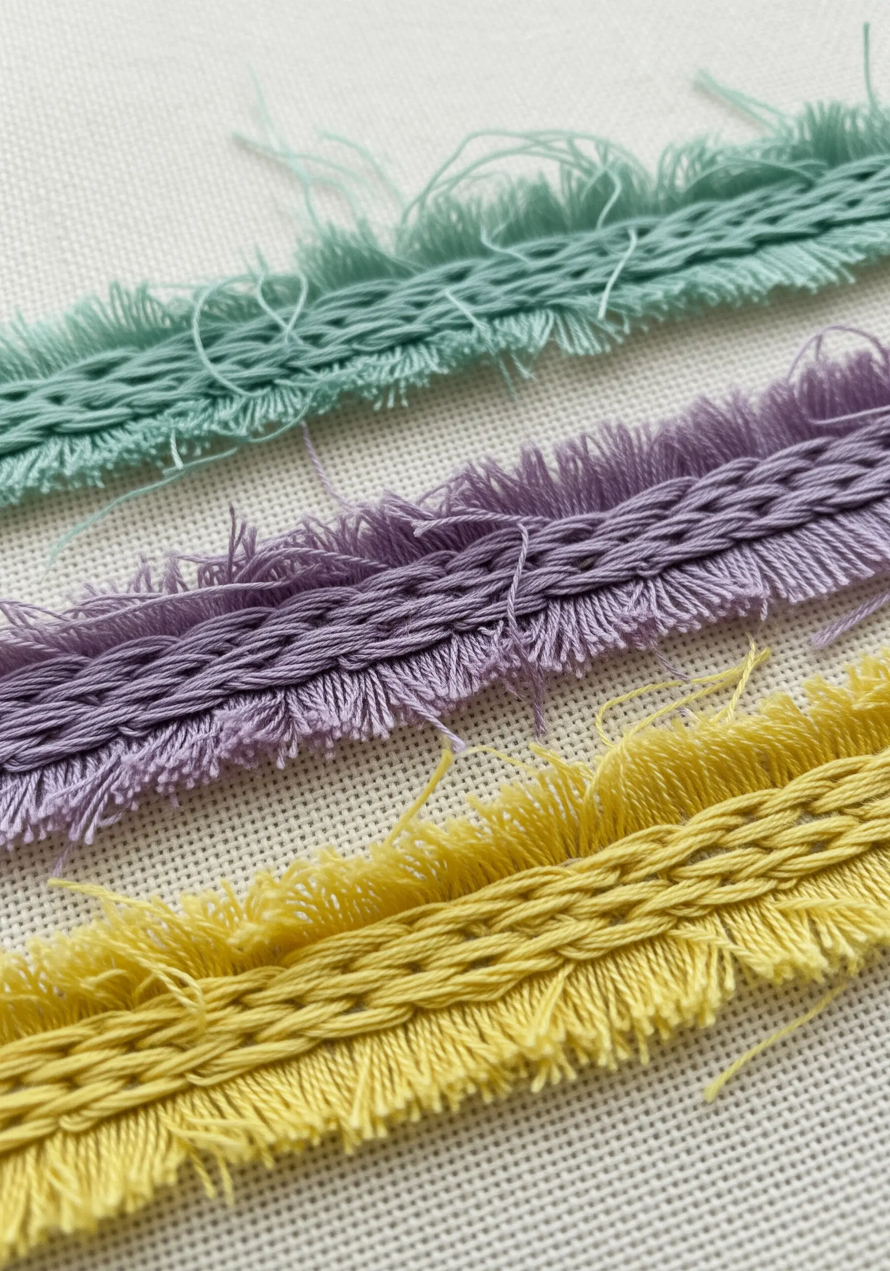 Samples of hand stitched fringe trim in pastel colors