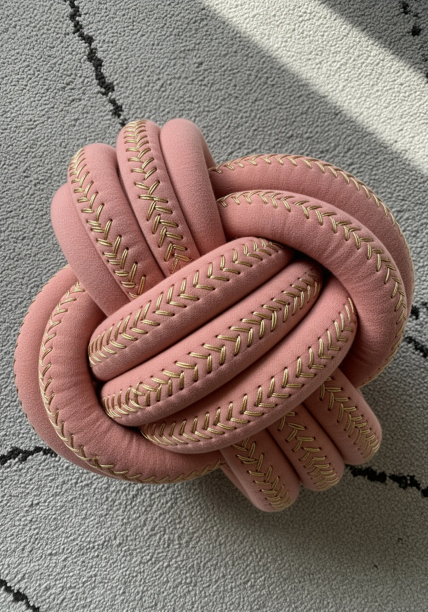 Pink knot cushion with gold herringbone stitching