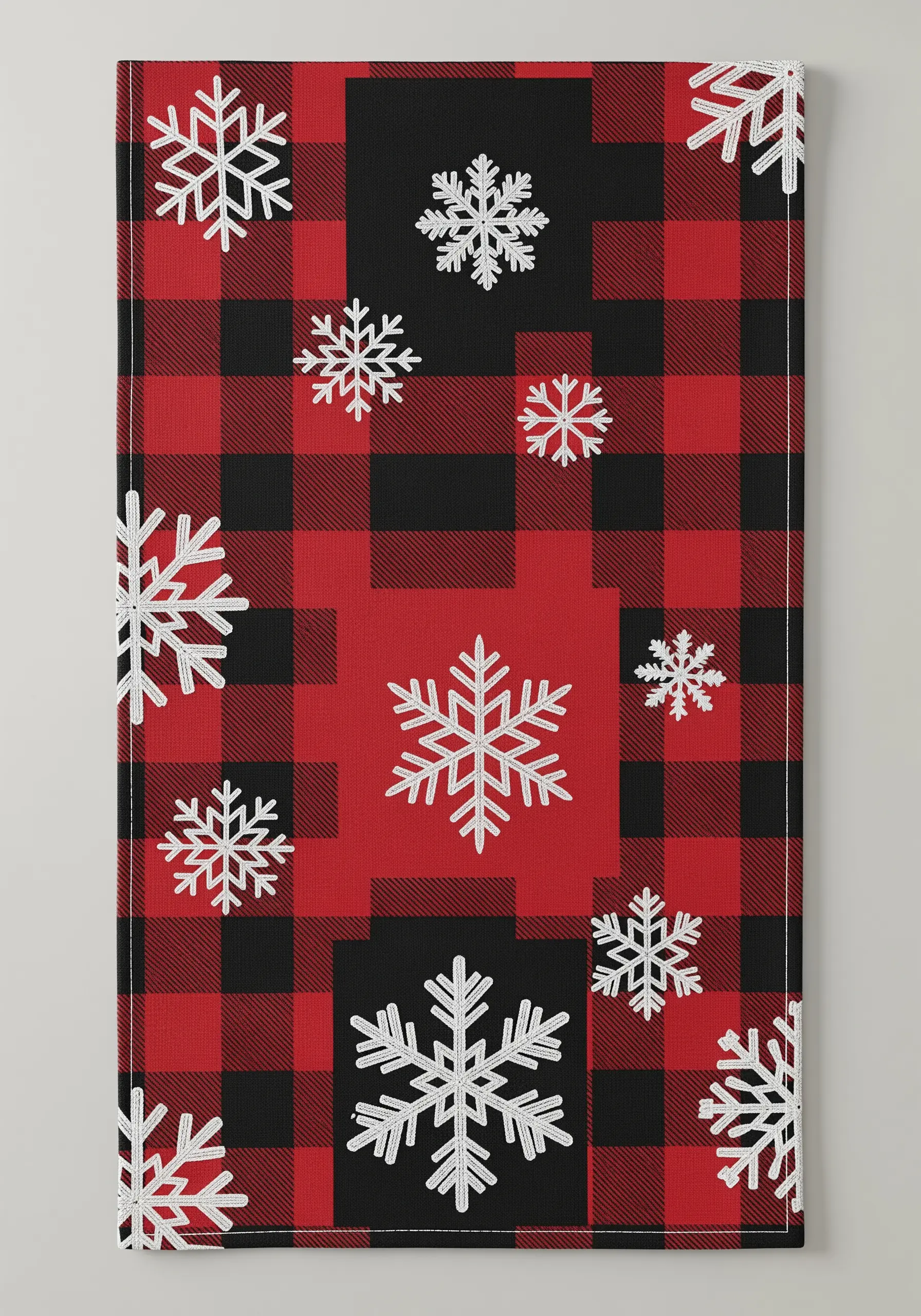 White embroidered snowflakes on a red and black buffalo plaid table runner.