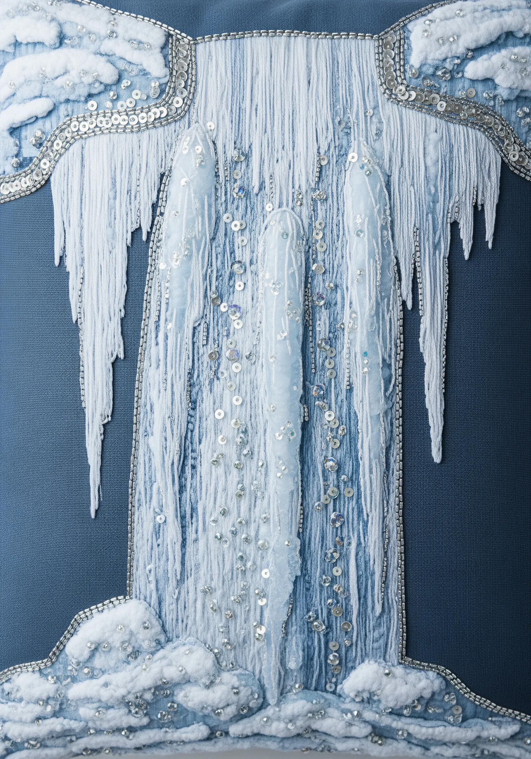 Close-up of a highly textured embroidered waterfall with yarn, sequins, and beads.