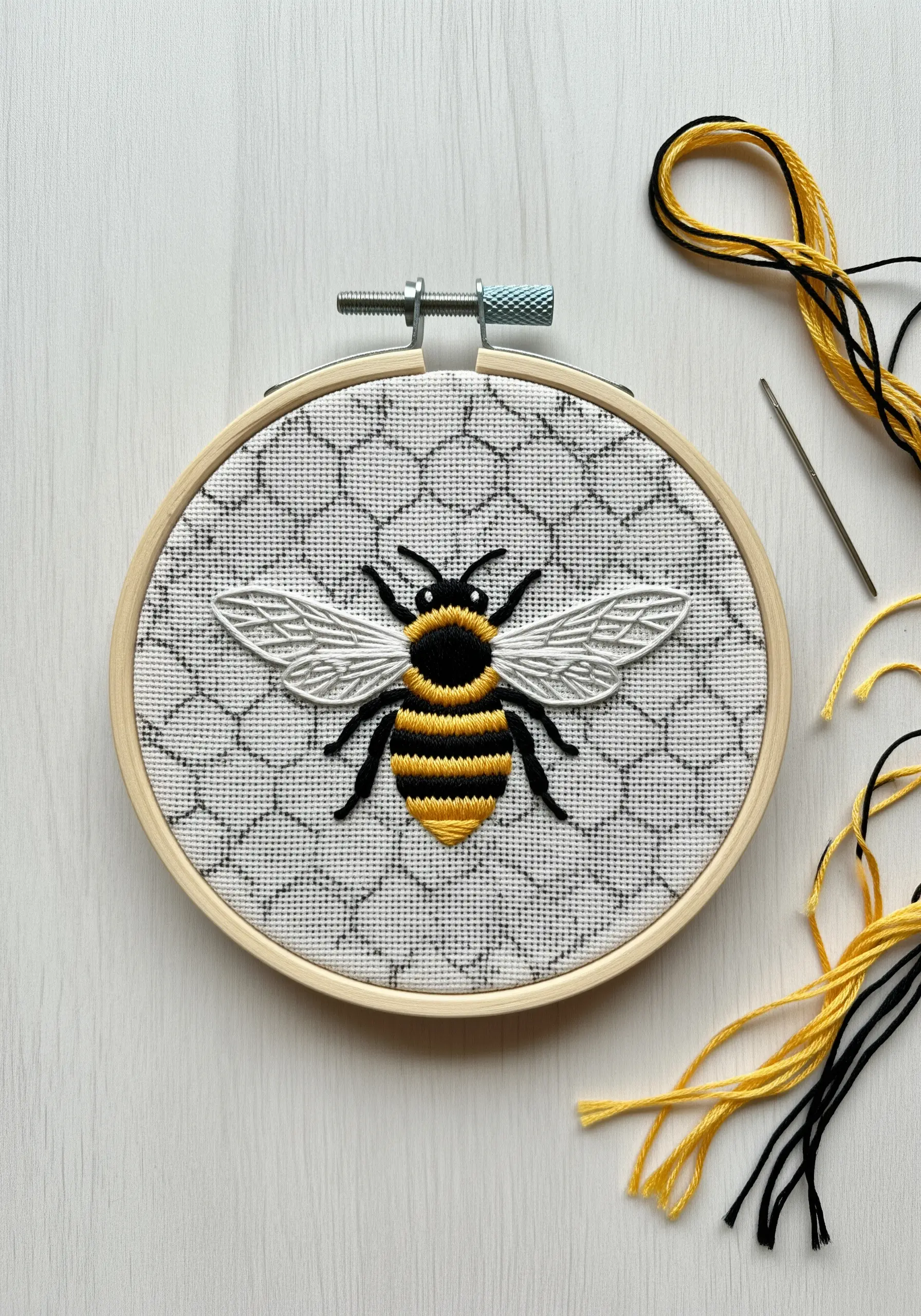 A realistically embroidered bee on a background of stitched gray chicken wire.