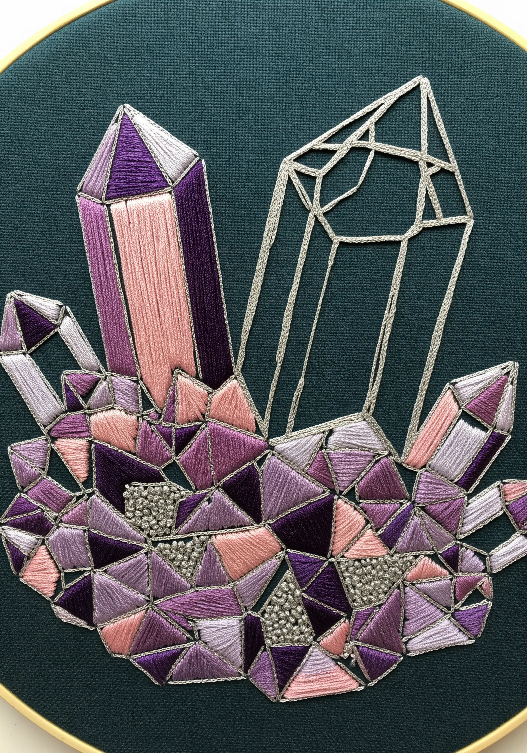 Embroidered crystals with some facets filled with satin stitch and others left as negative space outlines.