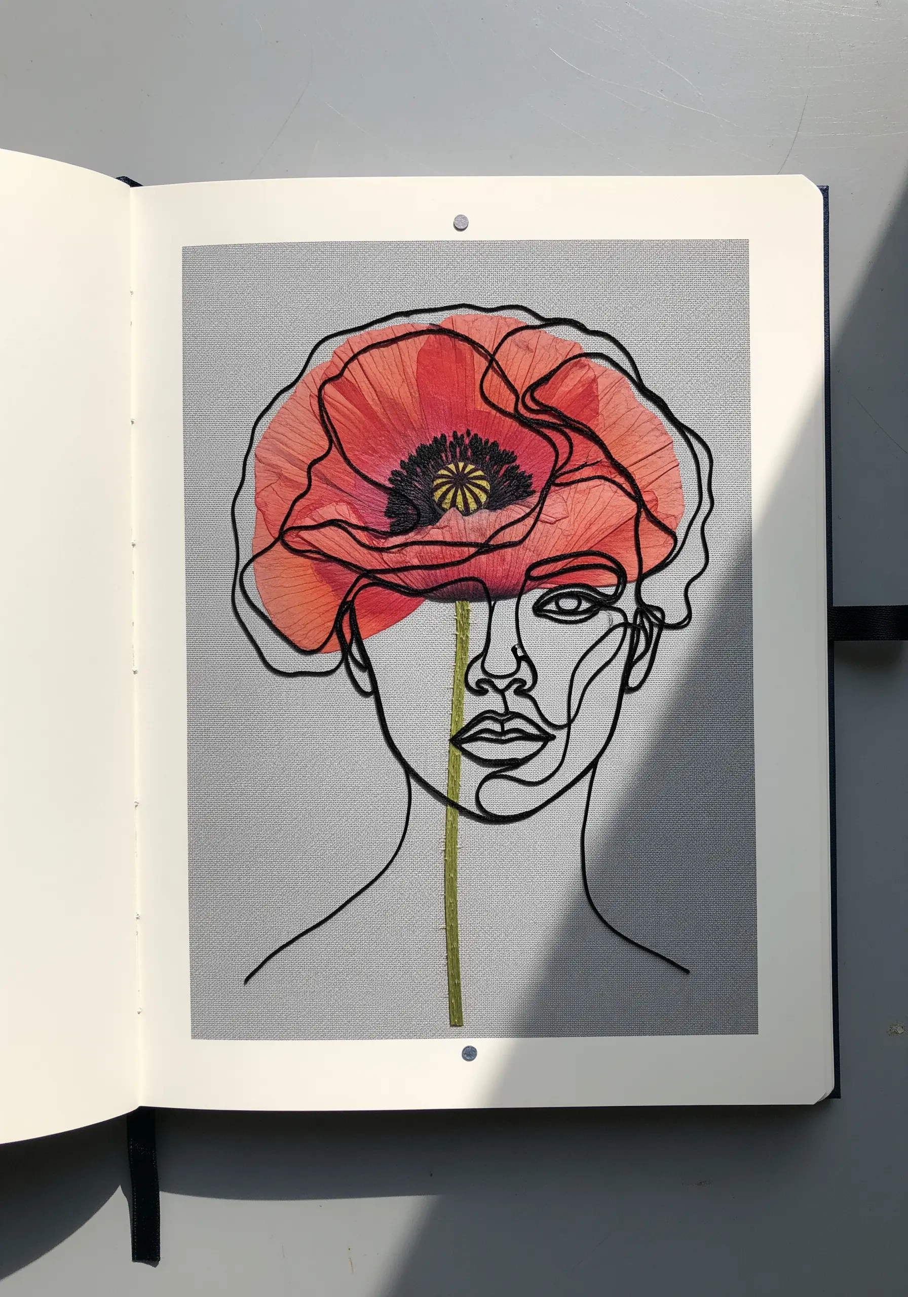 A single-line embroidered portrait with a large red pressed poppy integrated as hair.