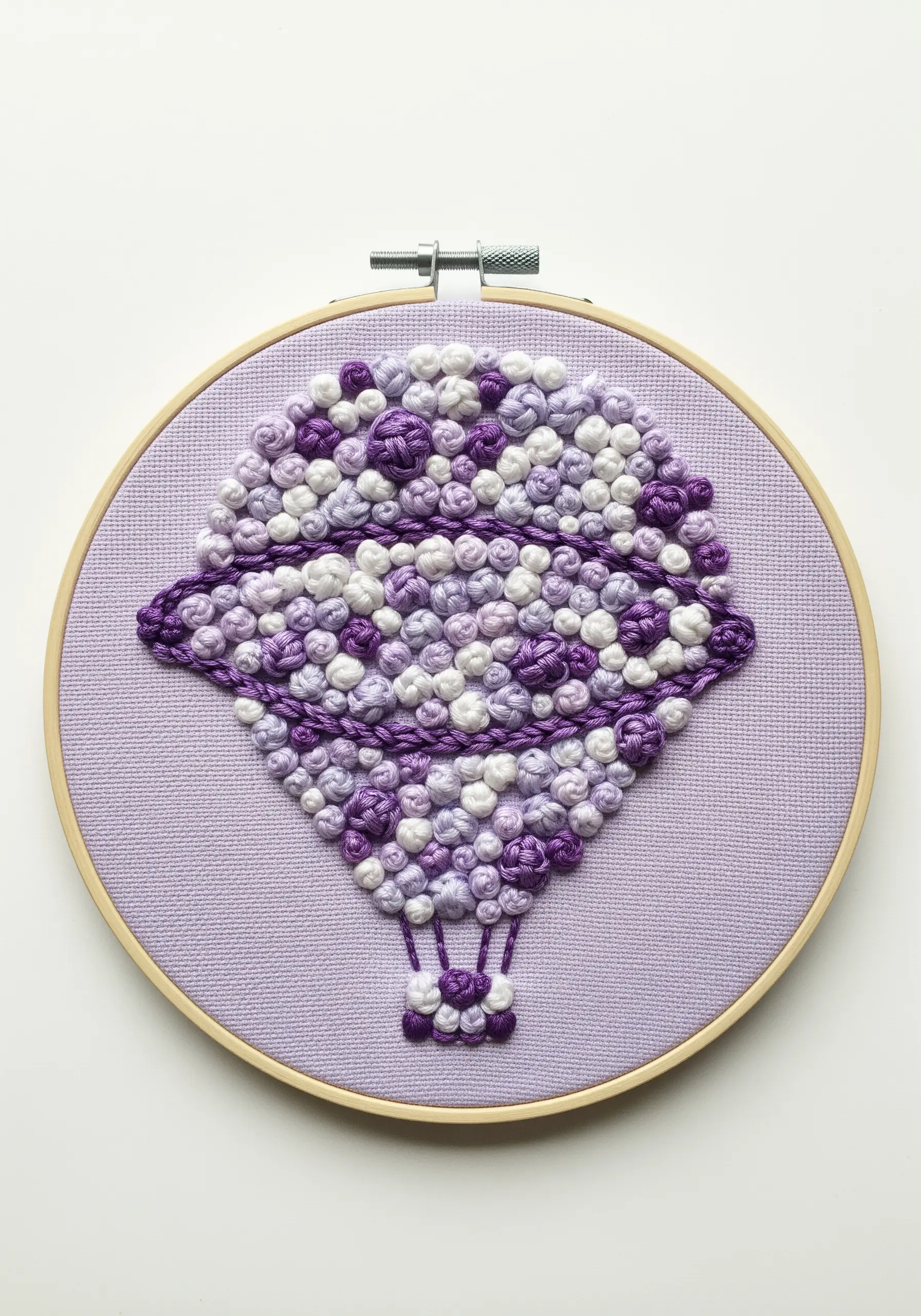 A hot air balloon filled with purple and white textural knots, with a central stripe of negative space.