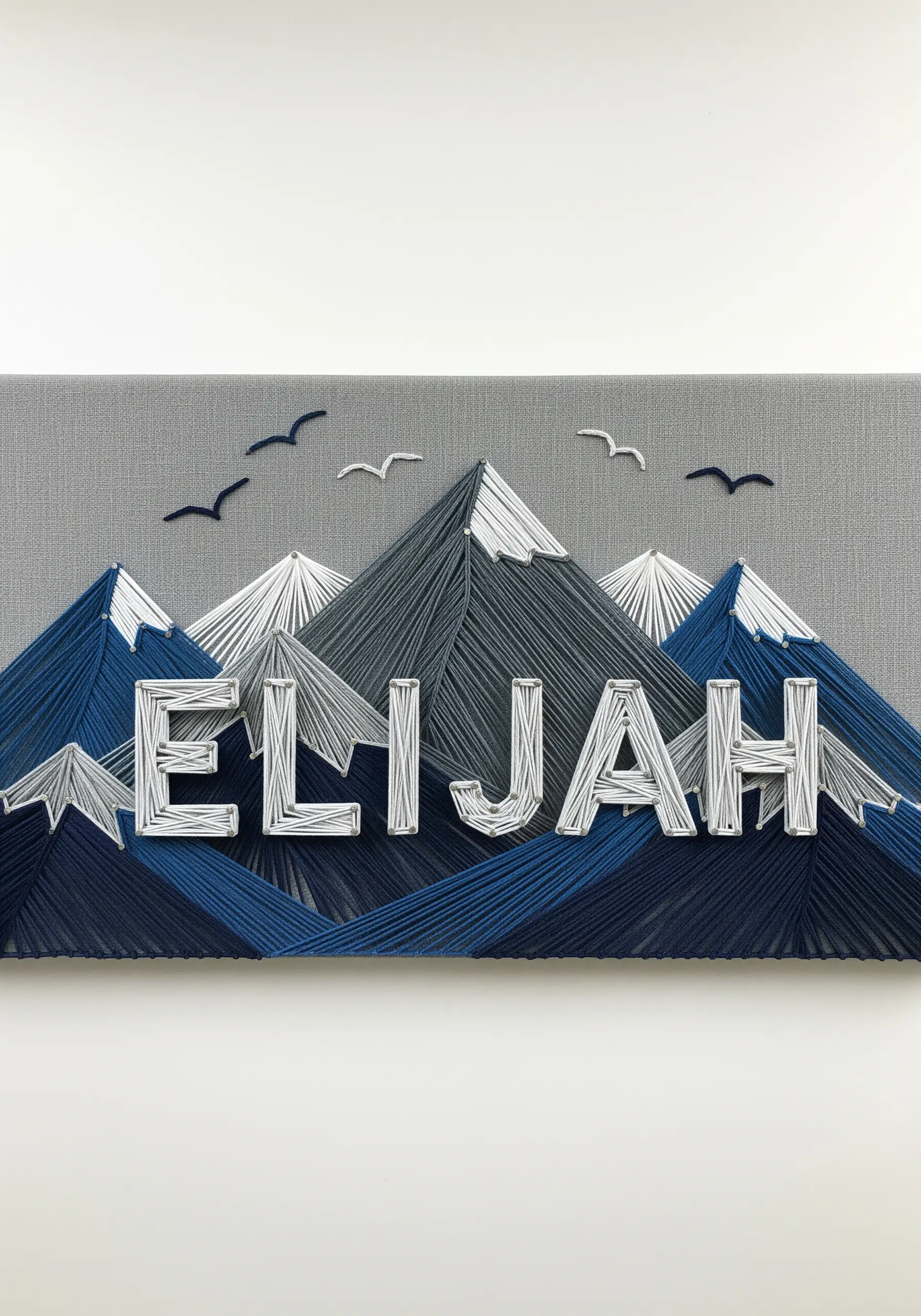 A name embroidered in white, set against a backdrop of stitched mountain peaks.