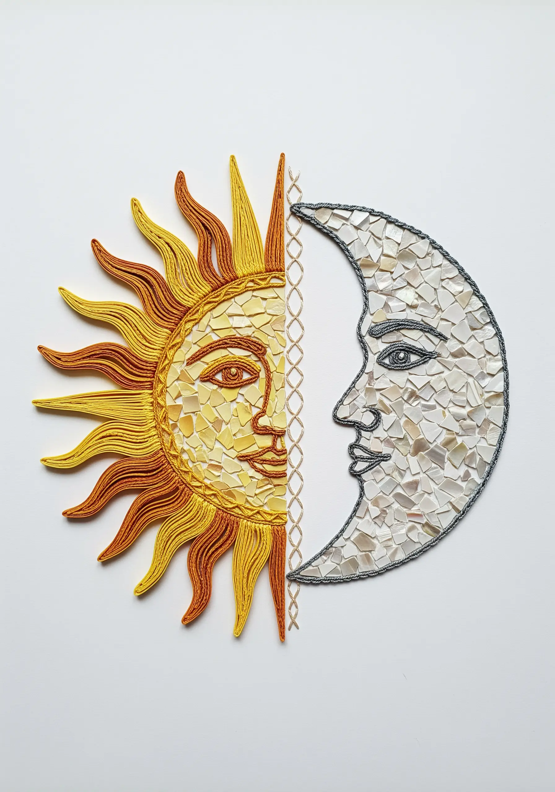 A celestial design showing half a sun (made of quilled paper) and half a moon (made of mosaic).