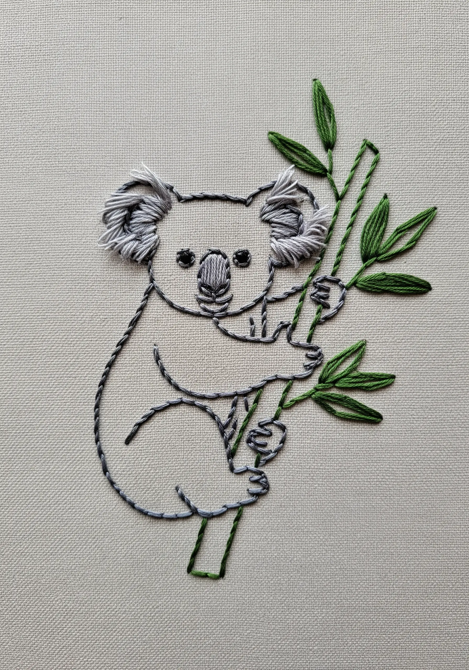 Koala embroidery on a branch with sketchy fur-like outlines