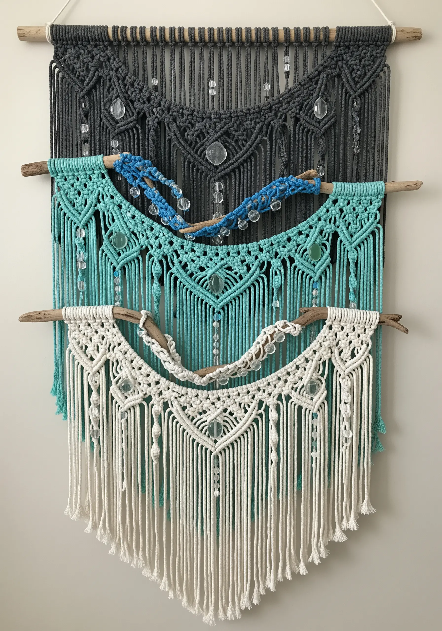 Layered macramé wall hanging in black, turquoise, and white with beads