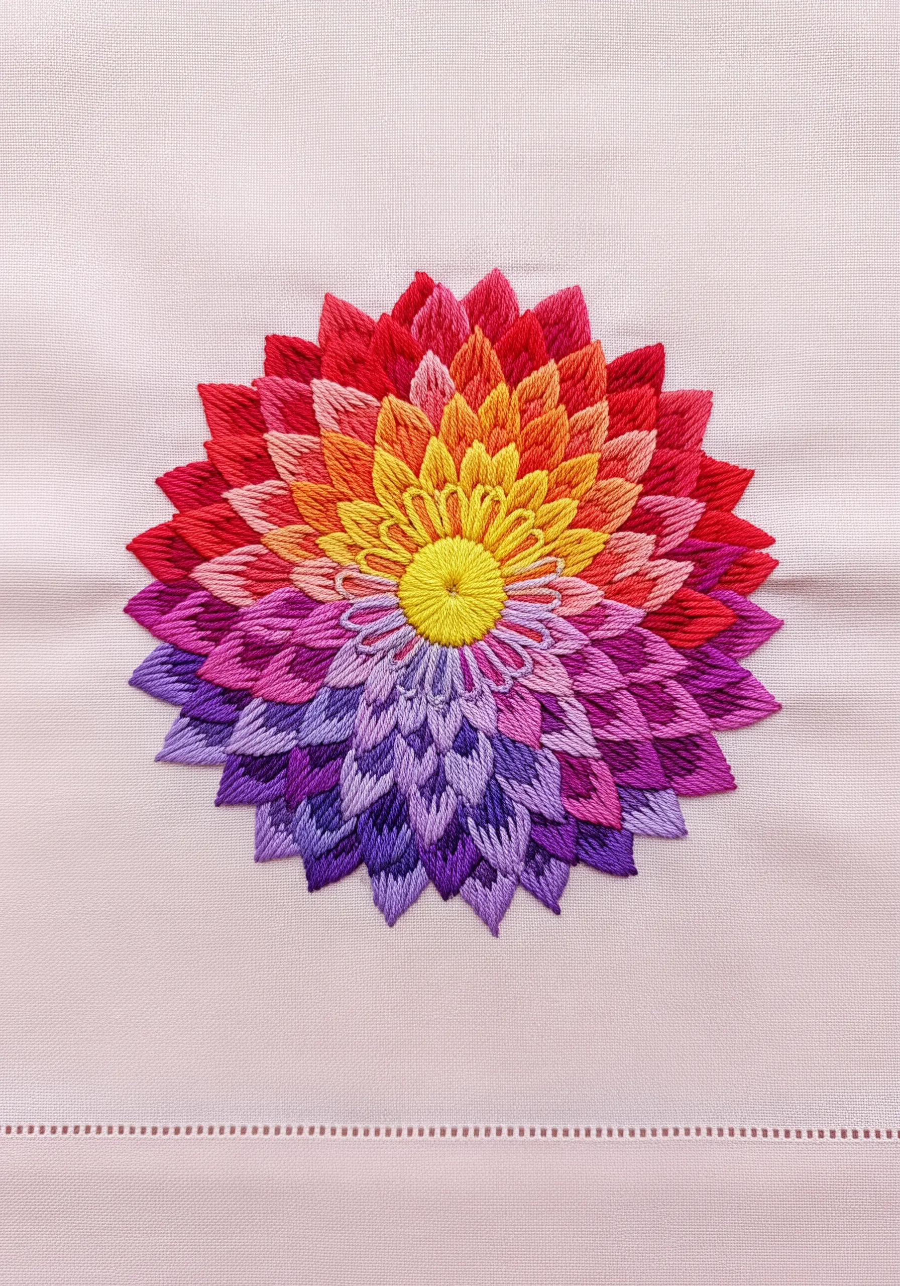 A large dahlia-style flower with layers of petals in a rainbow gradient.