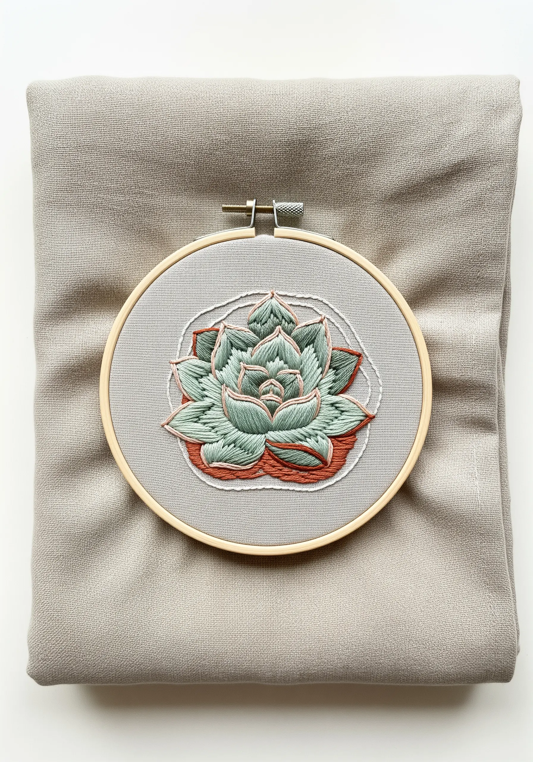 A multi-layered succulent embroidered with green, mint, and terracotta threads.