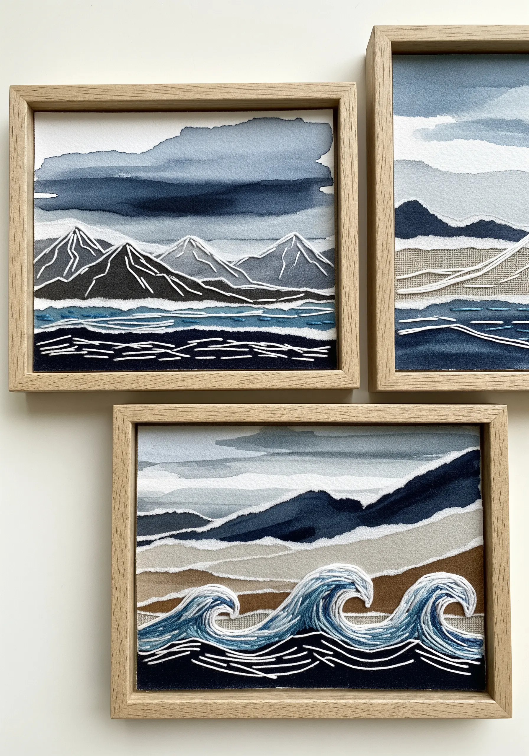 Three framed landscape collages made from torn paper, fabric, and linear embroidery details.