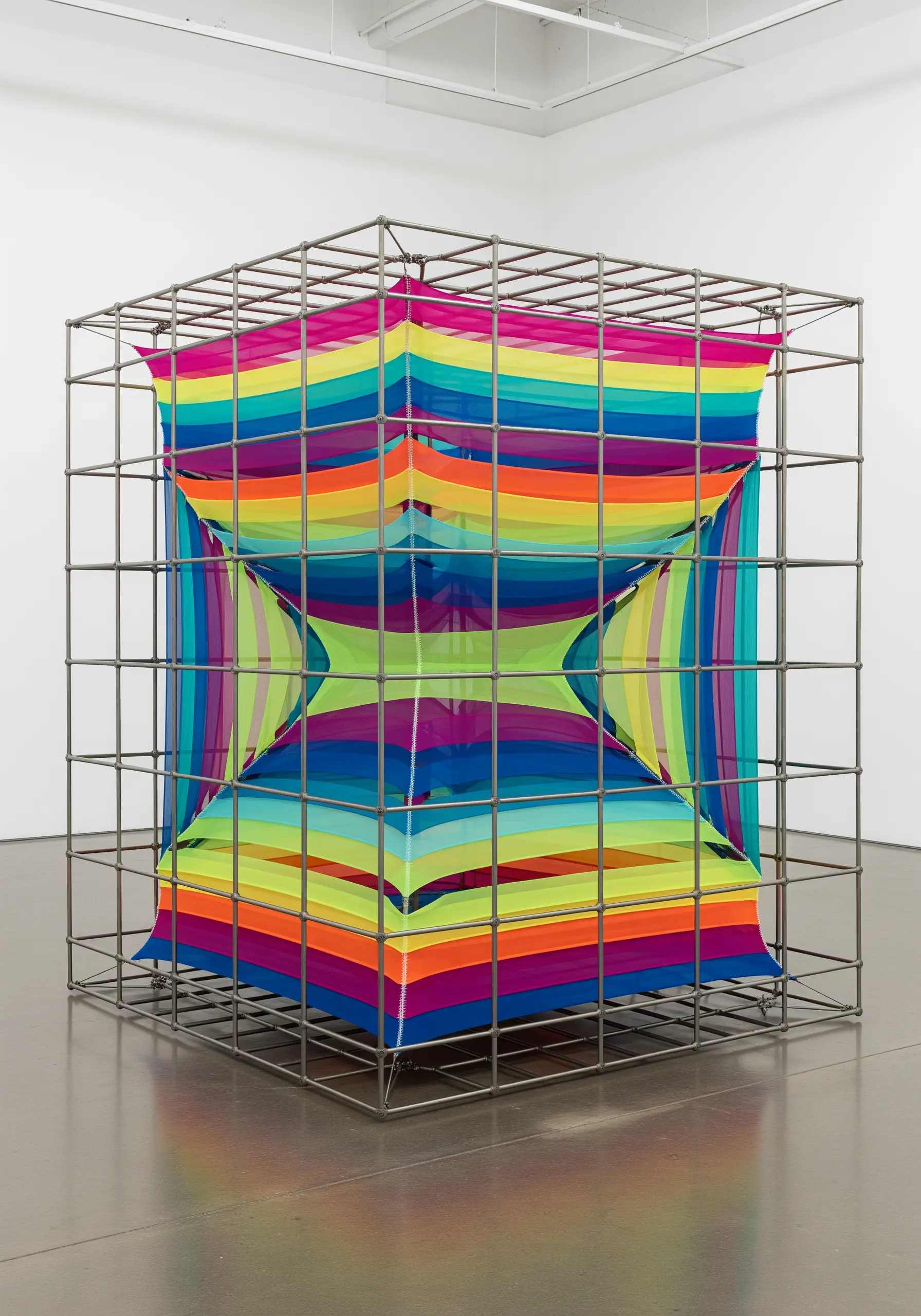 Metal grid cube with stretched layers of colorful sheer fabric