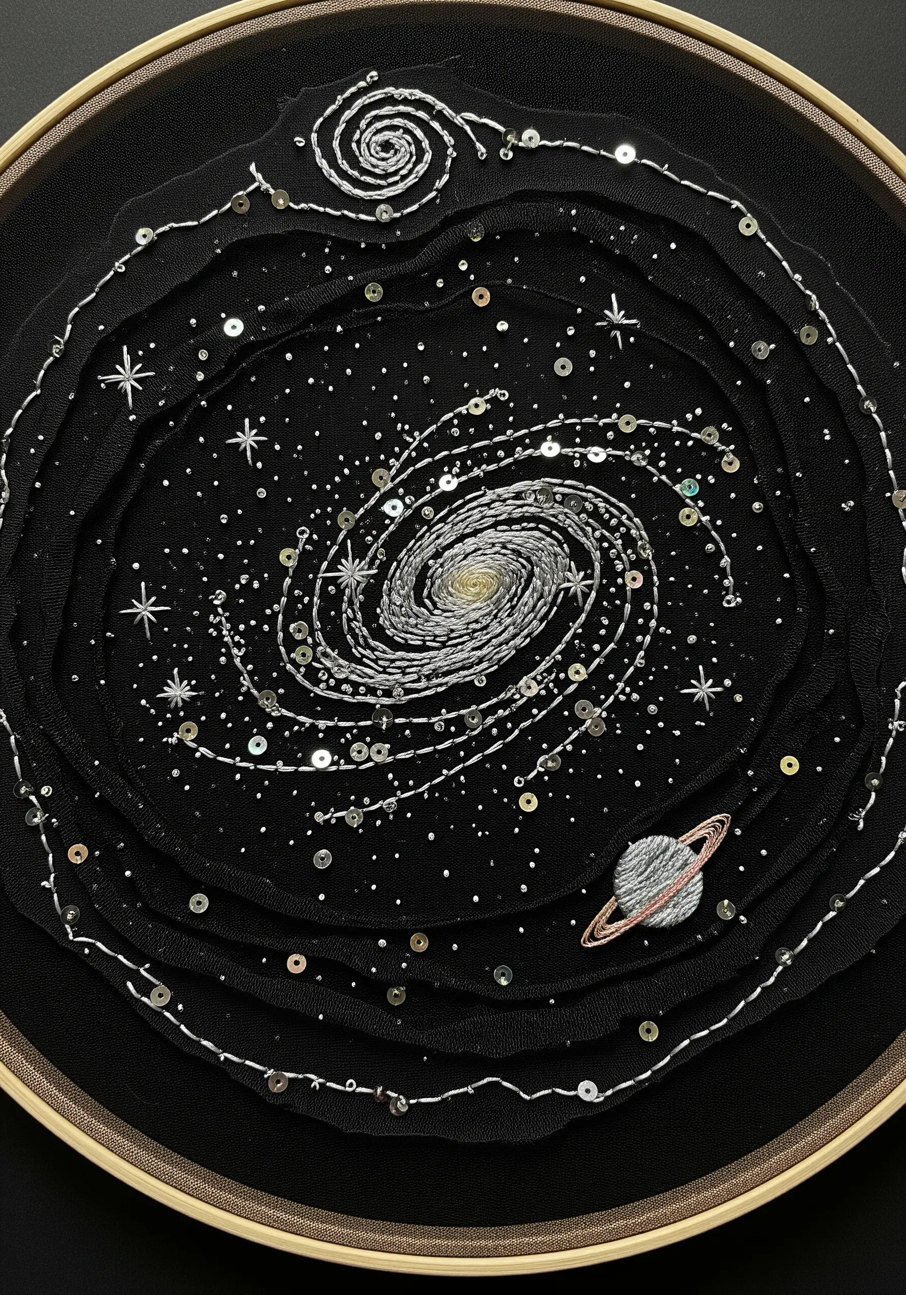 Embroidered galaxy on layered black tulle with sequins and silver metallic thread.