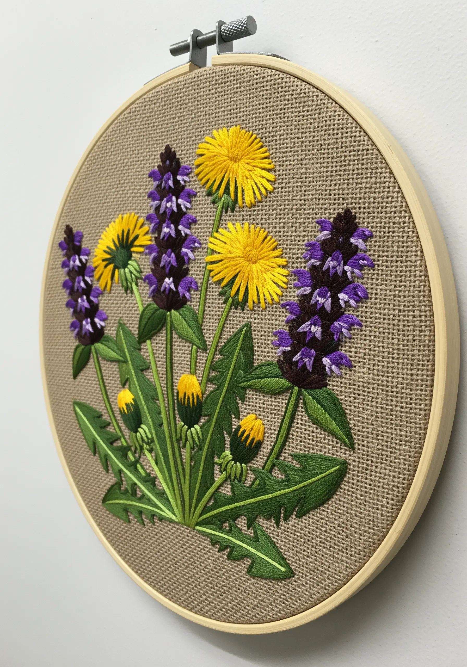 Embroidery of dandelions and other wildflowers on a textured, neutral-colored burlap fabric.