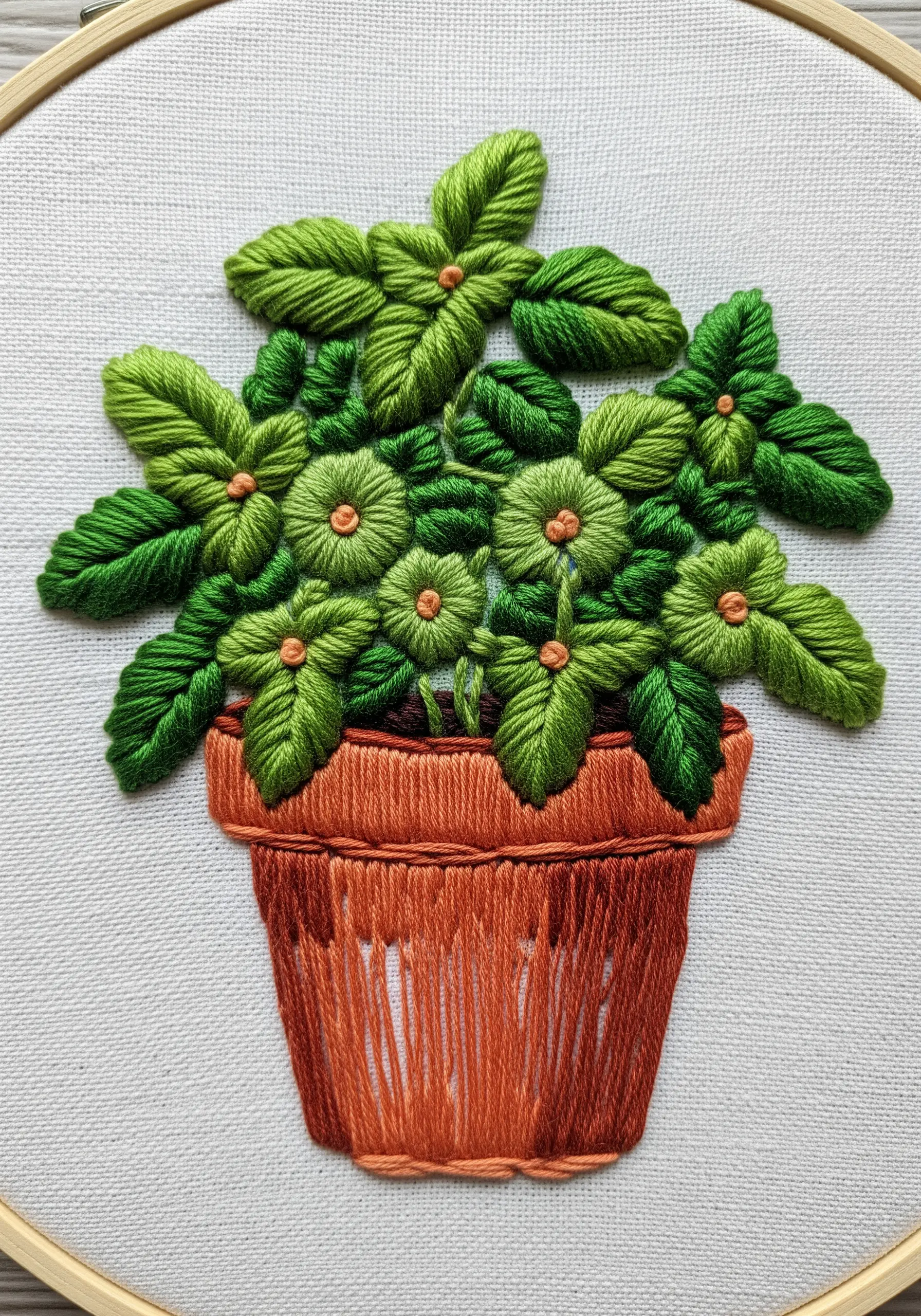 Potted herb embroidery with dense green fishbone stitch leaves
