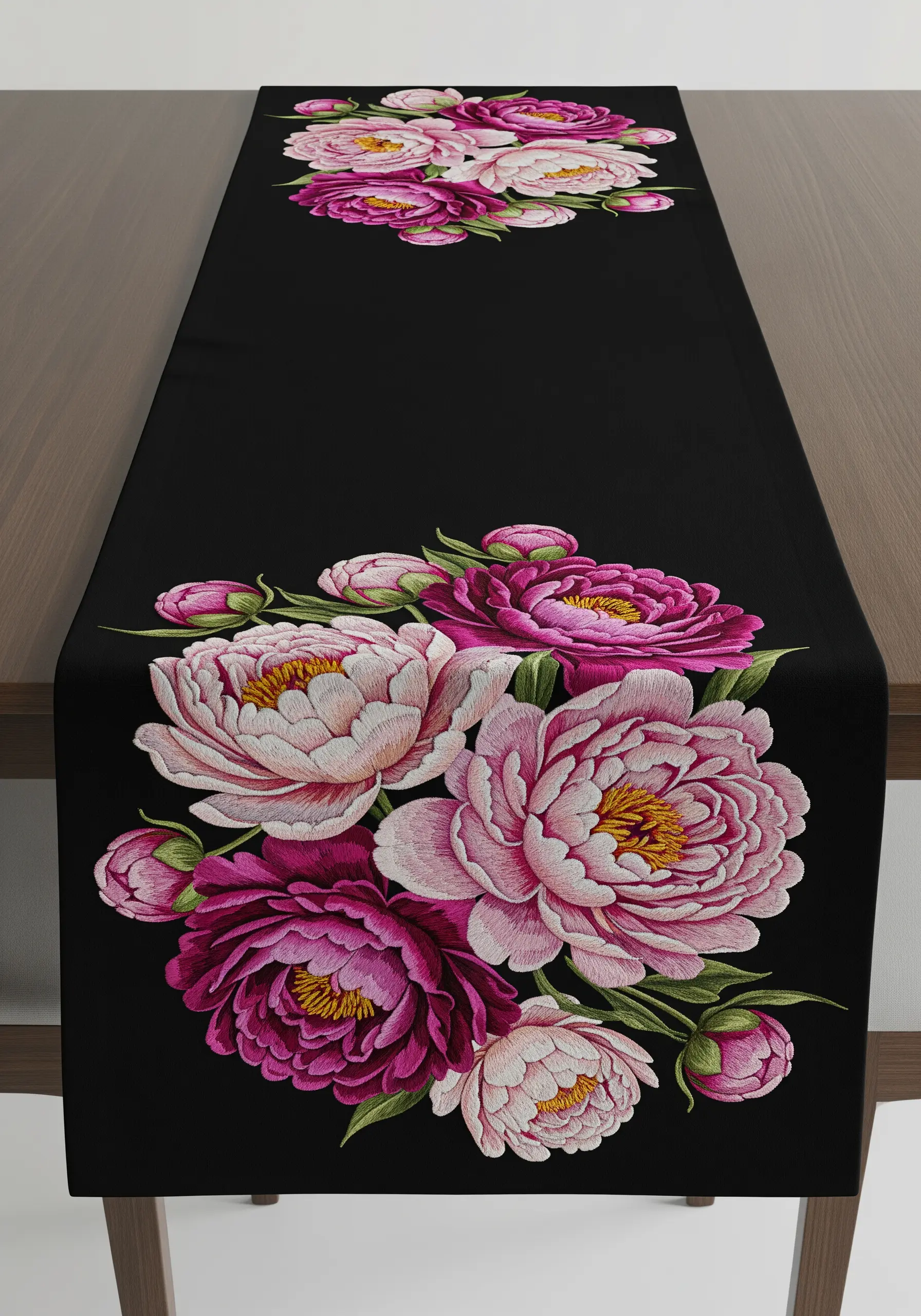 Large, detailed pink and magenta peonies embroidered on a black table runner.