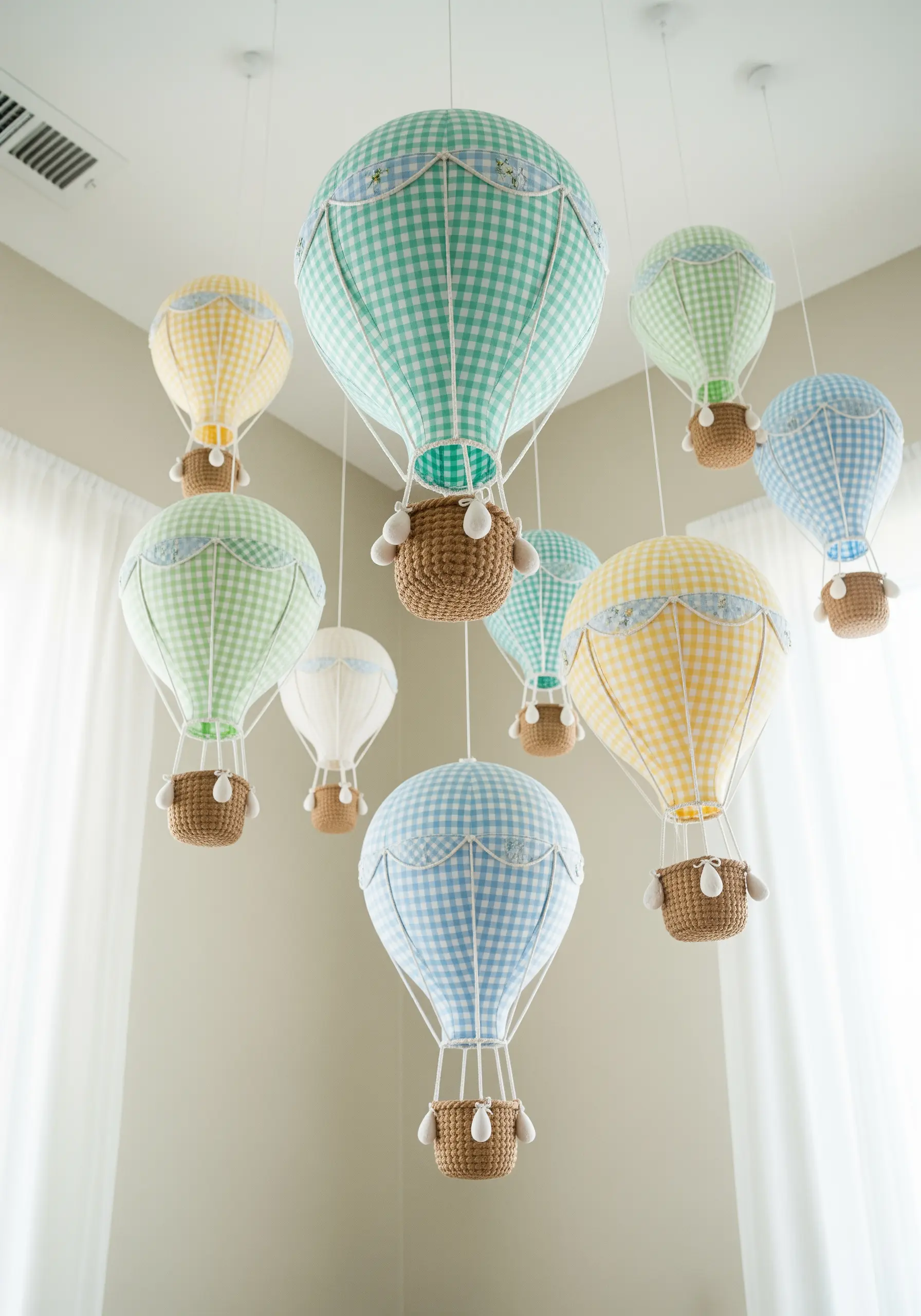 A nursery mobile made of miniature hot air balloons in pastel gingham fabrics.