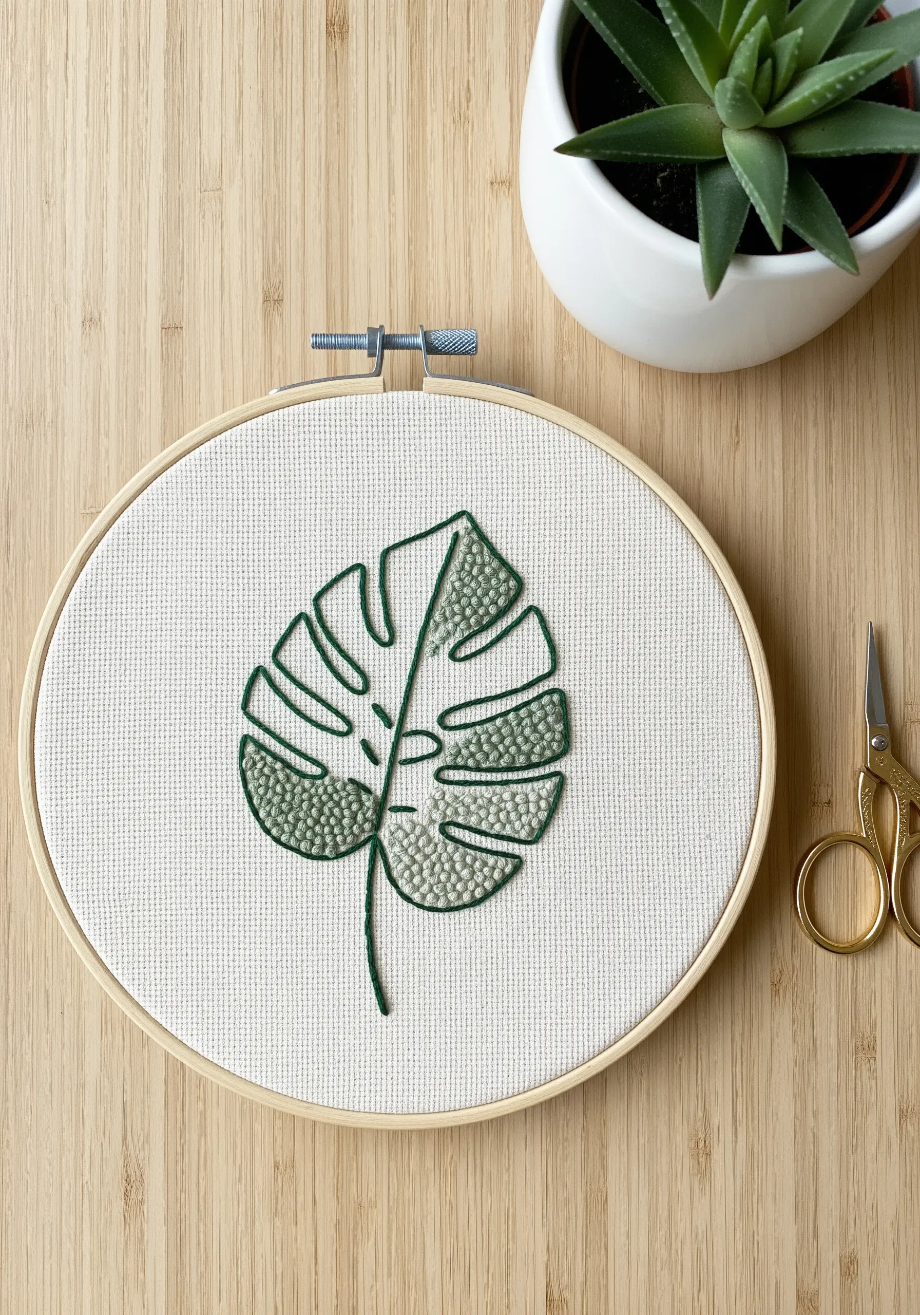 Monstera leaf embroidery with two-tone green French knot fill stitch.
