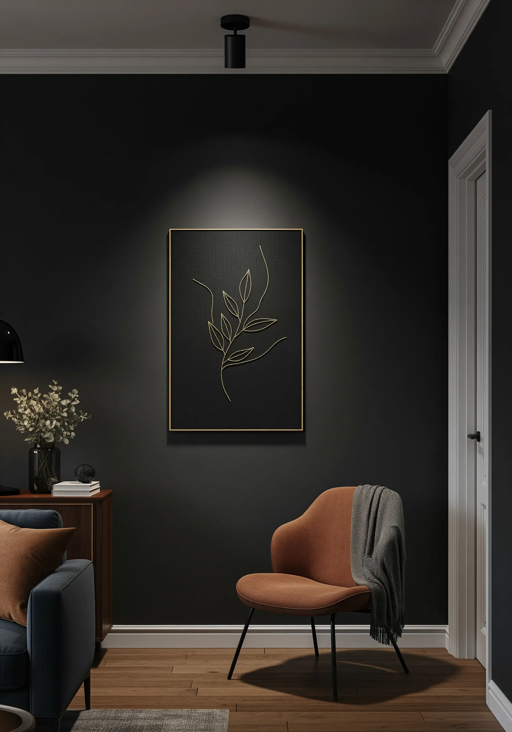 A framed piece with a single gold metallic thread embroidered leaf on a black background.