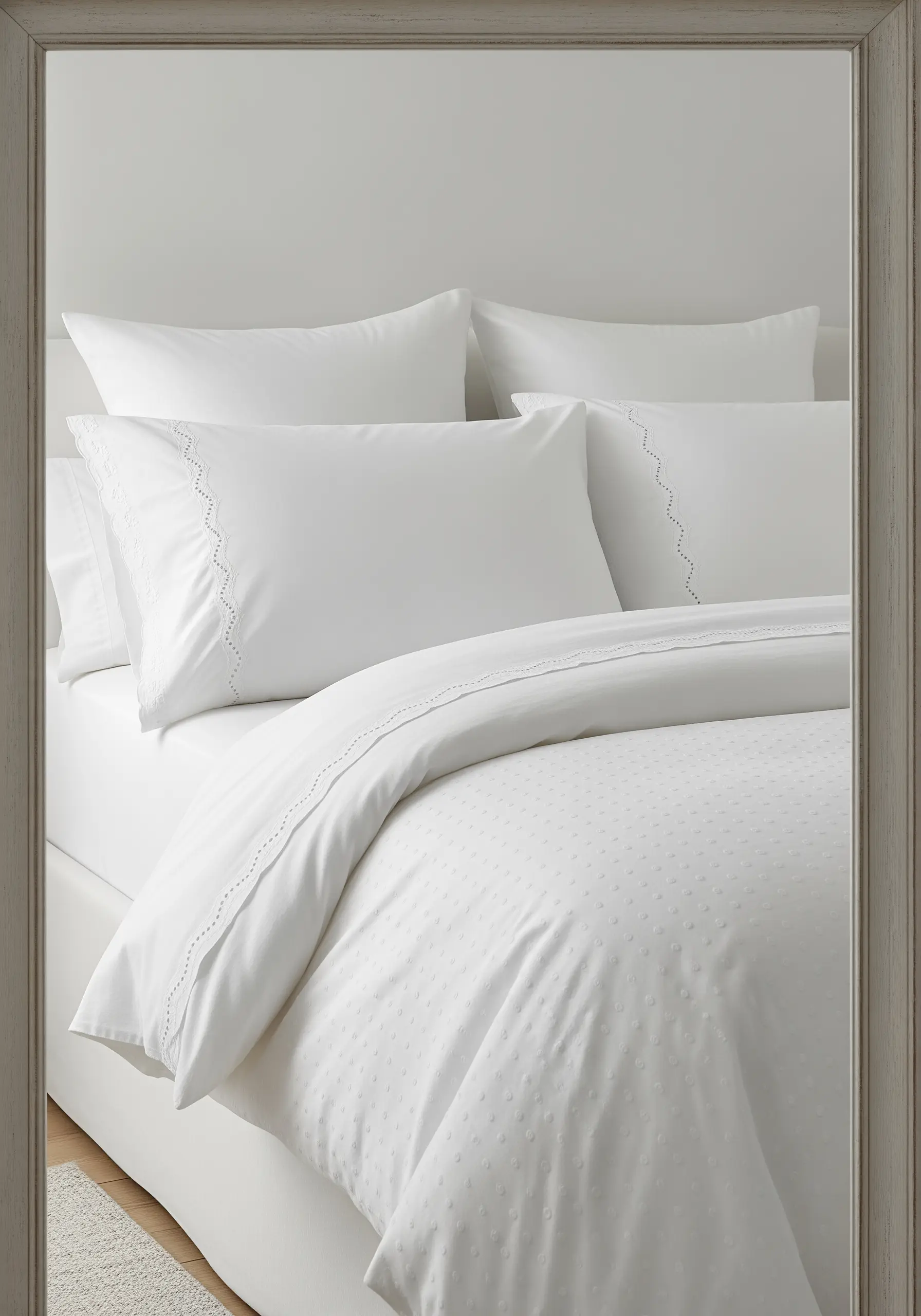Crisp white bedding with subtle white-on-white embroidery details, like French knots and drawn thread work.