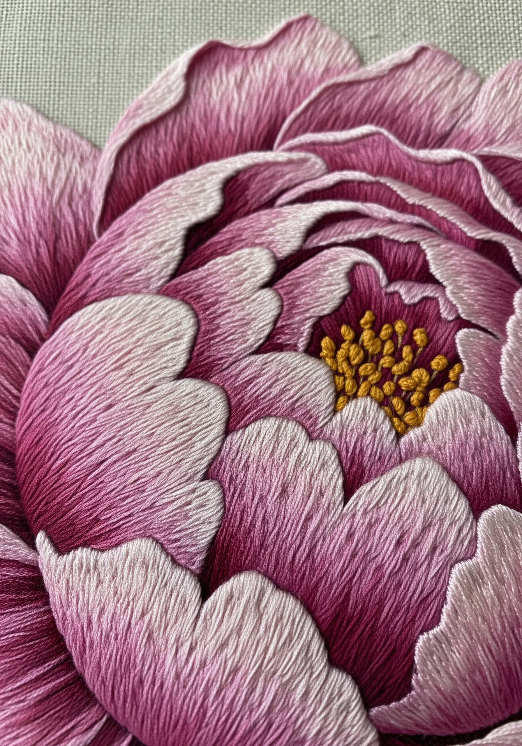 Close-up embroidery of a pink peony using long and short stitch for shading