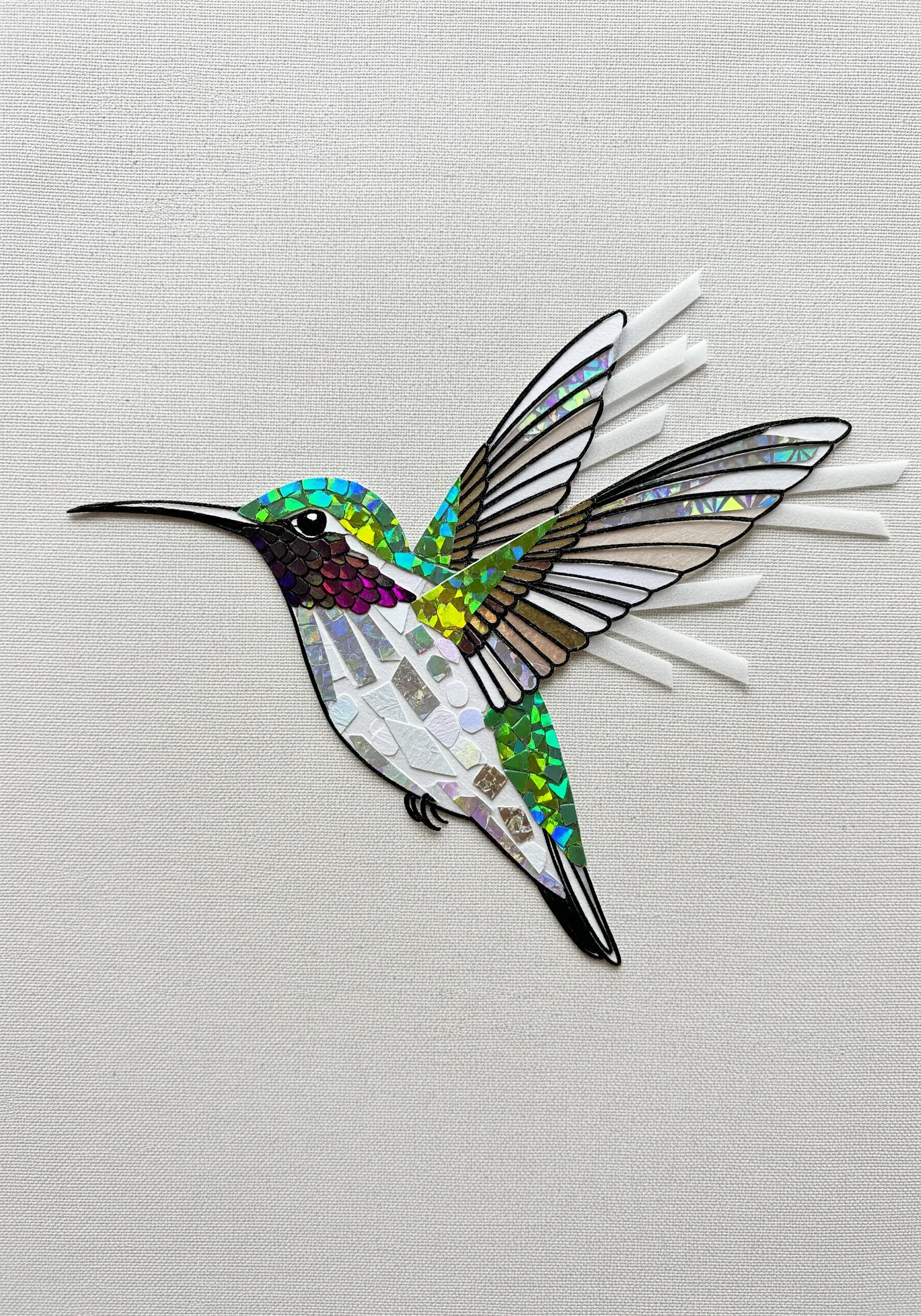 A mosaic-style paper collage of a hummingbird with iridescent green and purple feathers.