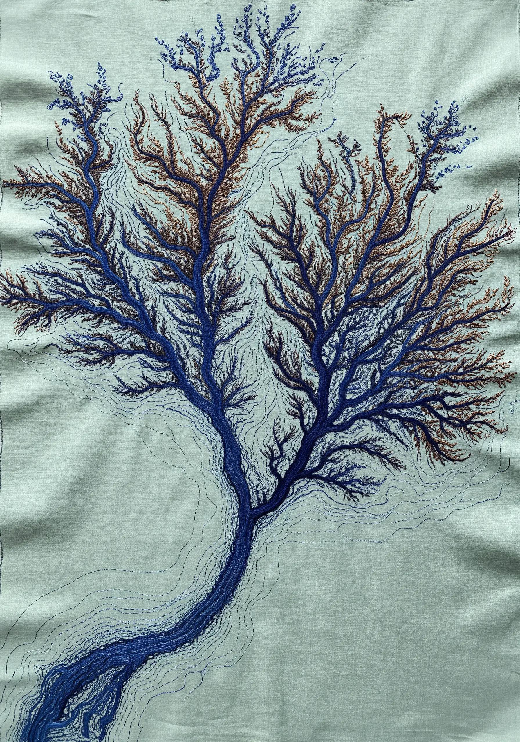 Detailed embroidery of a tree or coral with intricate branching patterns in blue and brown.