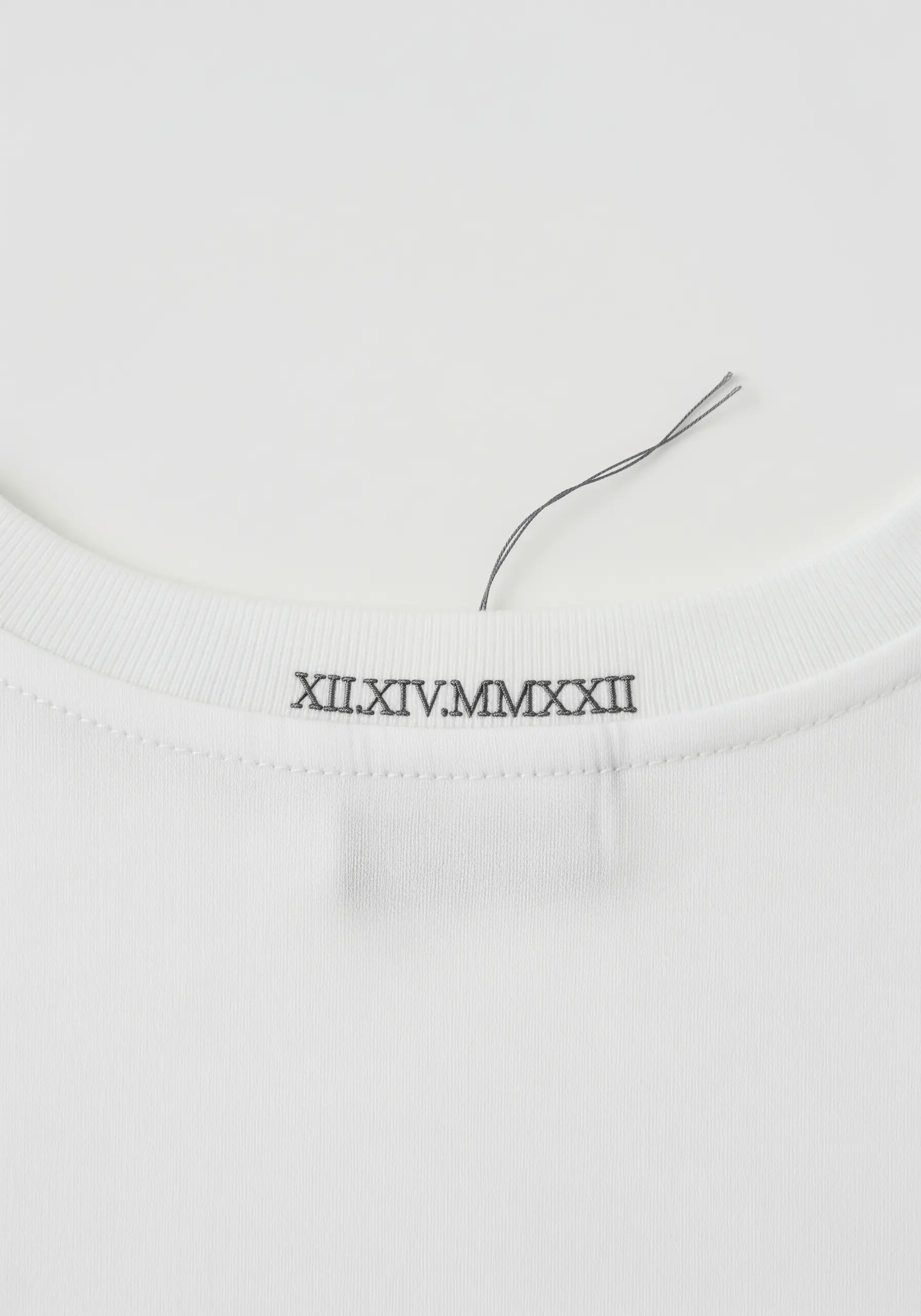 A significant date in Roman numerals embroidered in grey on the t-shirt collar.