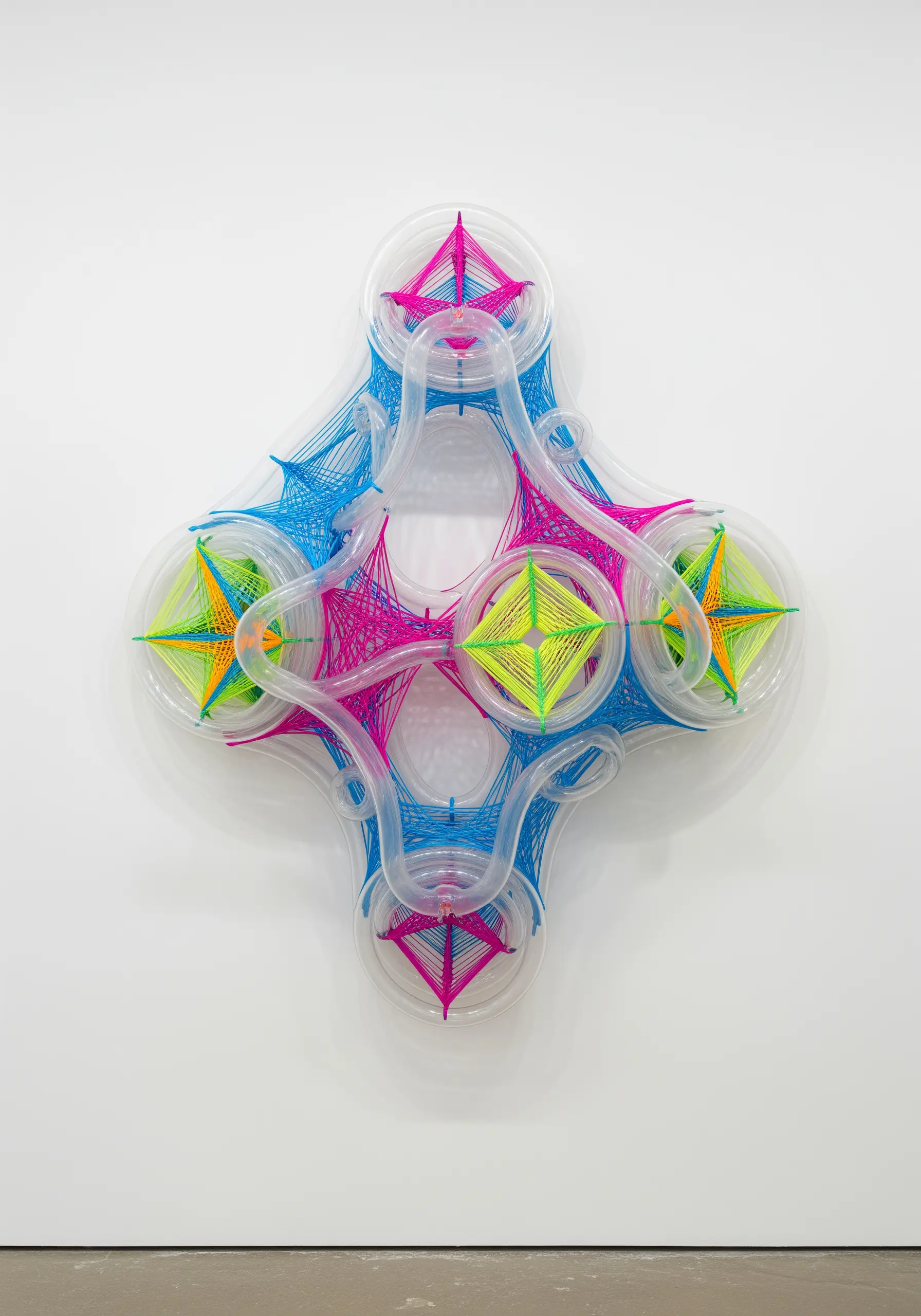 A futuristic string art sculpture using neon pink, blue, and green thread on a clear frame.