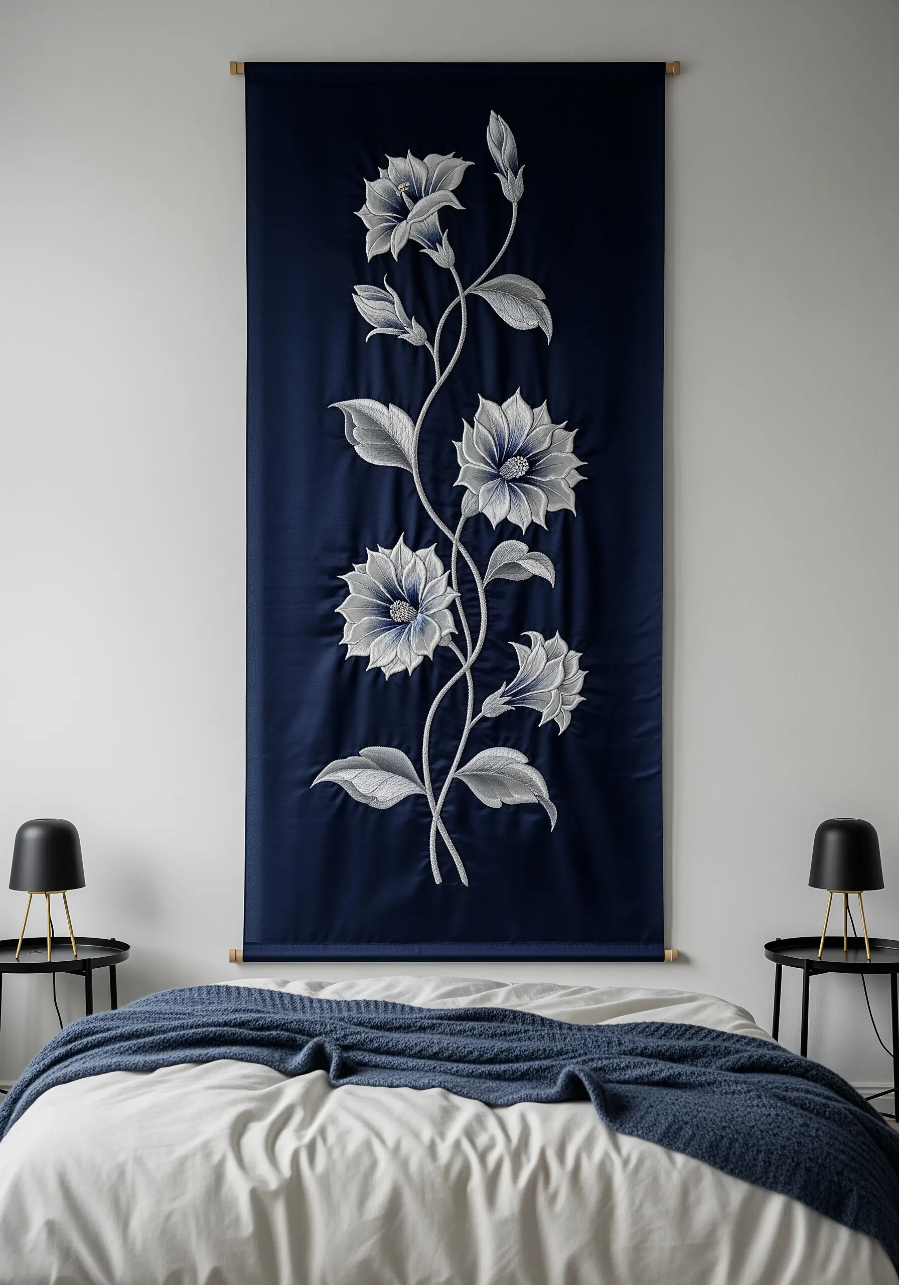 A single white and silver climbing flower embroidered on a navy blue wall hanging.
